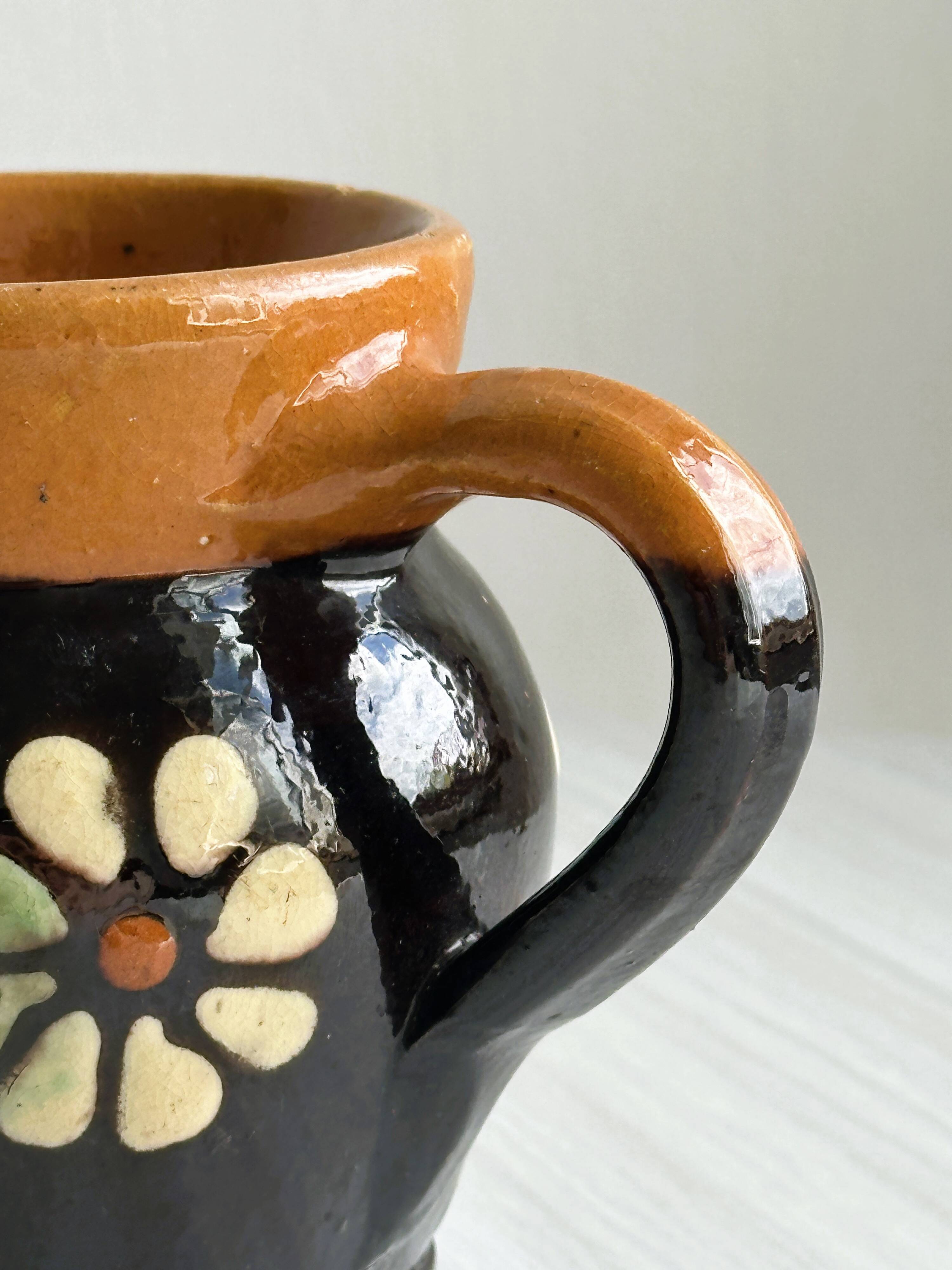 Petit pichet Alsacien en céramique noire et marron, décoré de motifs floraux peints à la main.