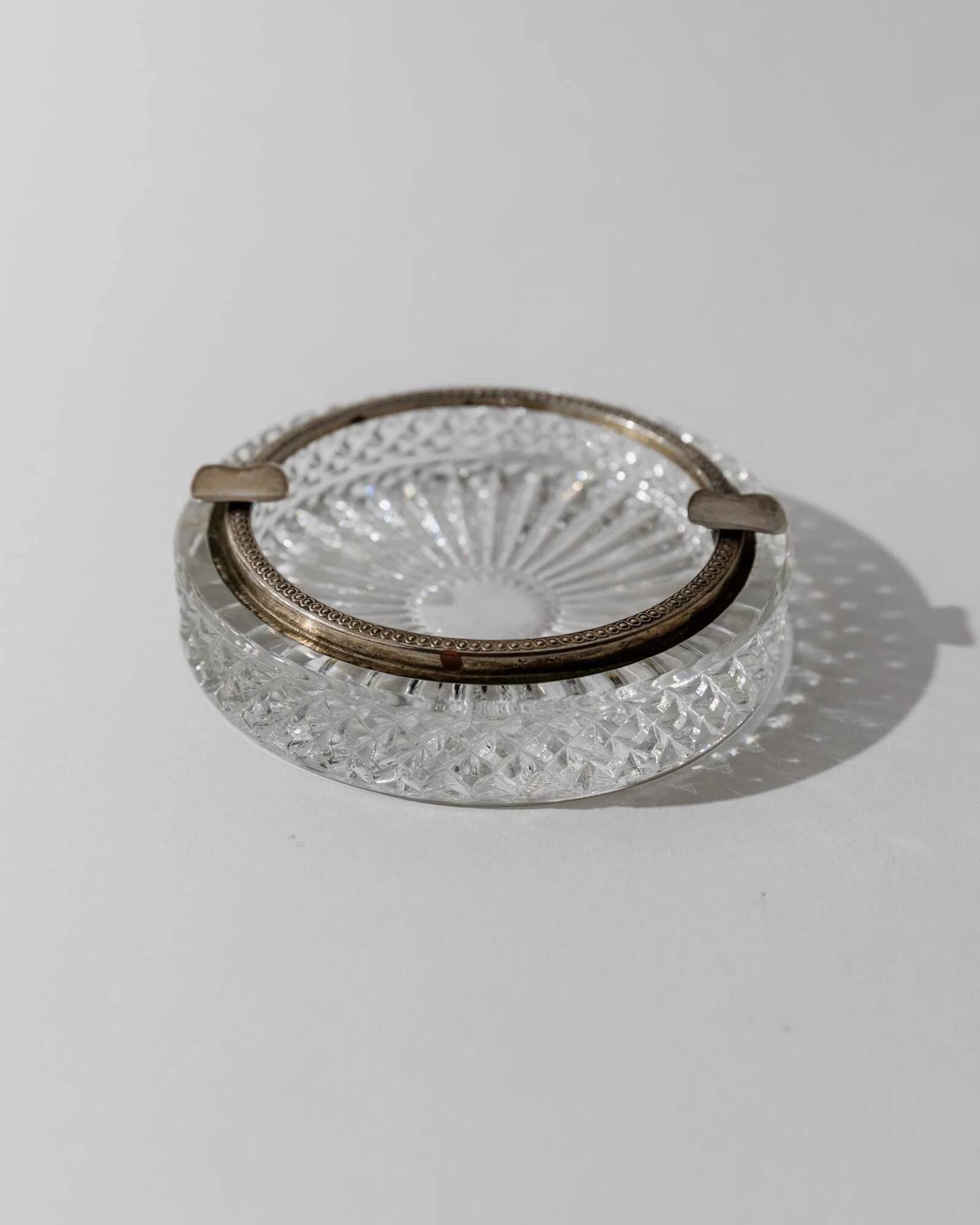 Vintage crystal glass ashtray from the 1920s, silver-edged with a textured pattern, Art Deco table decoration.