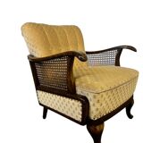 Vintage wooden armchair with rattan weaving.
