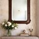 Italian sculpted mirror, patinated brown and gold wood, architectural frame from the 1960s.