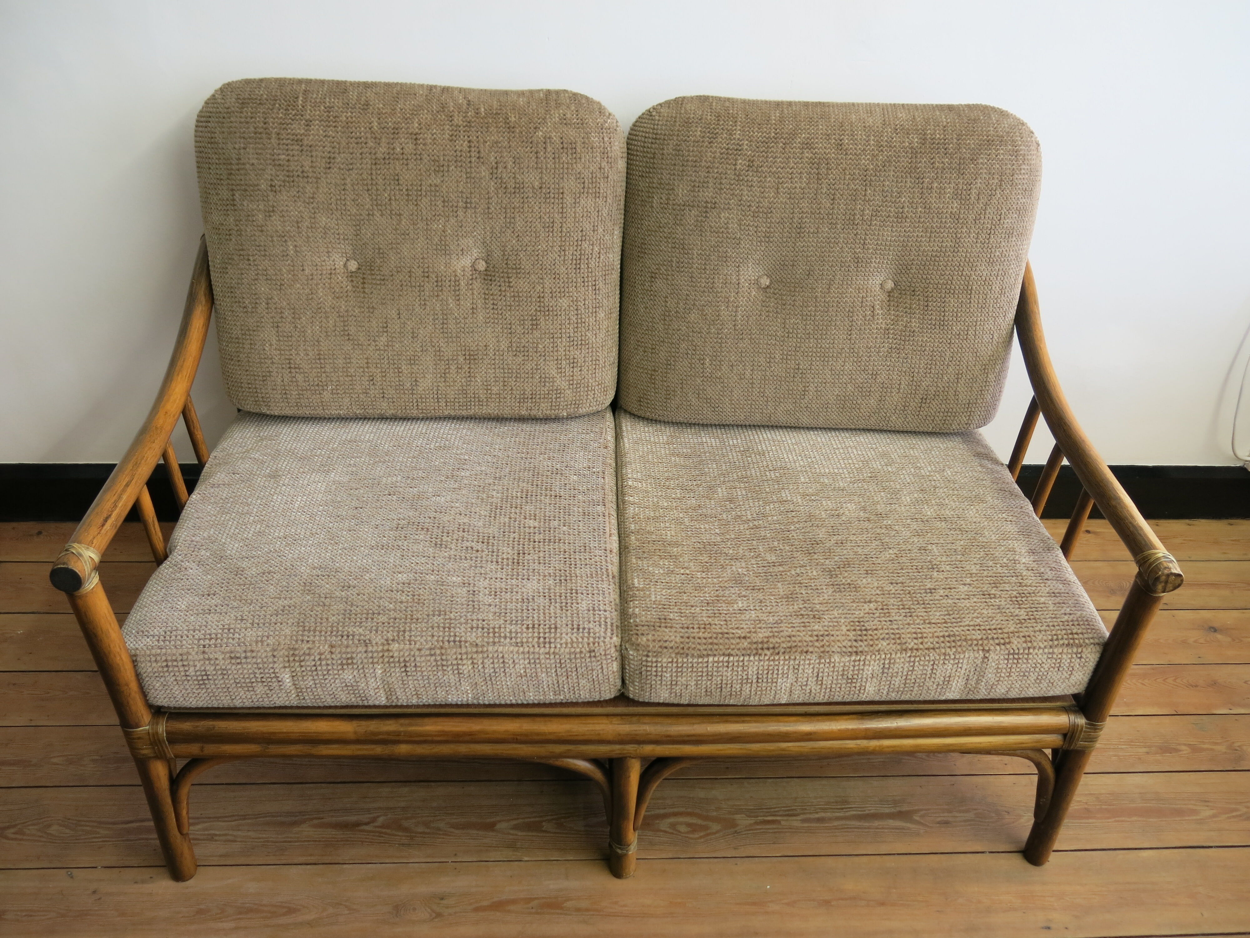 Two-seater rattan sofa with natural tones