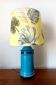Blue ceramic lamp with claw feet and foliage lampshade.