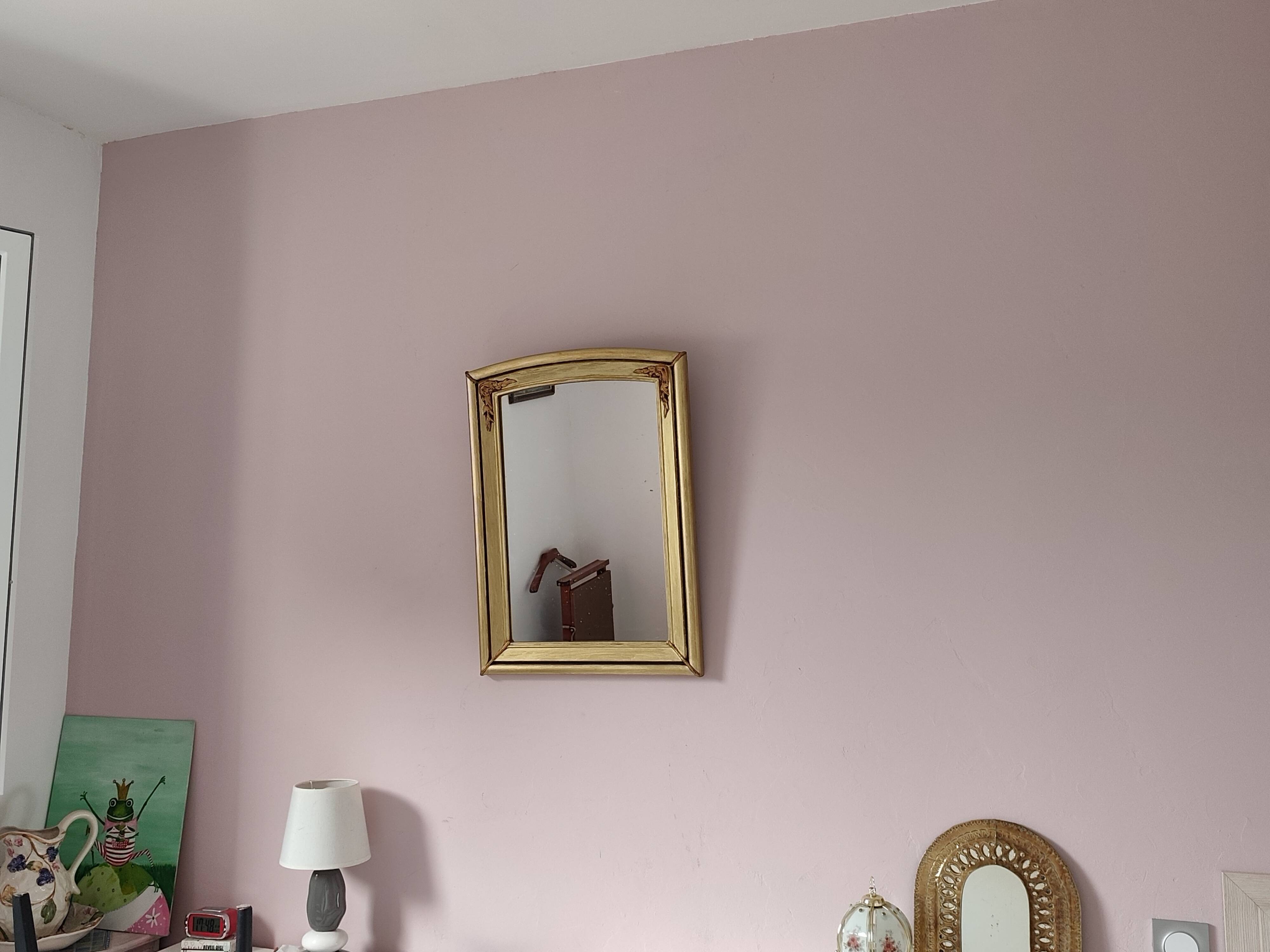 Art Deco mirror in gilded wood with curved floral decorations.