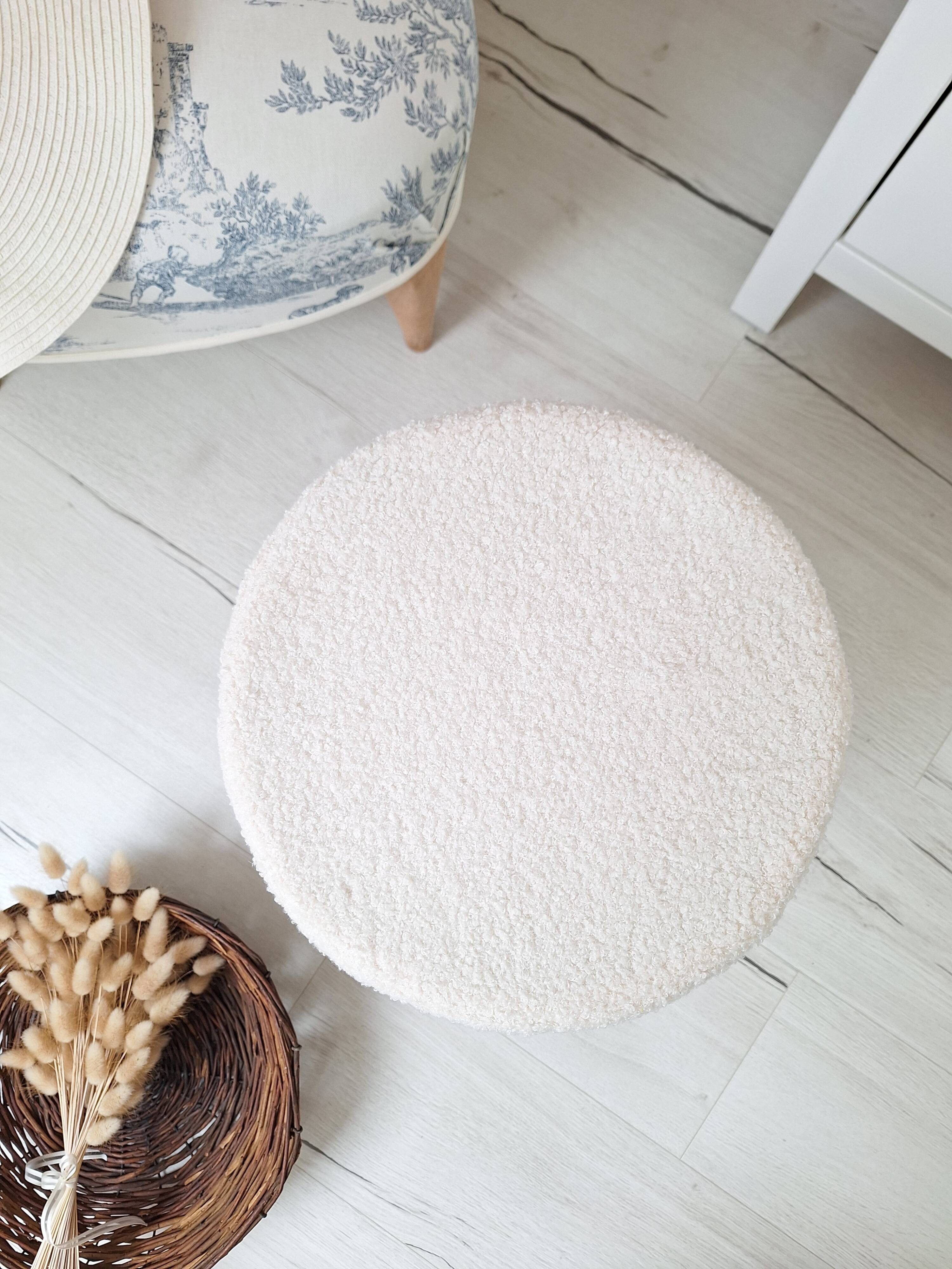 Black iron stool/pouf with its boucle fabric cushion.