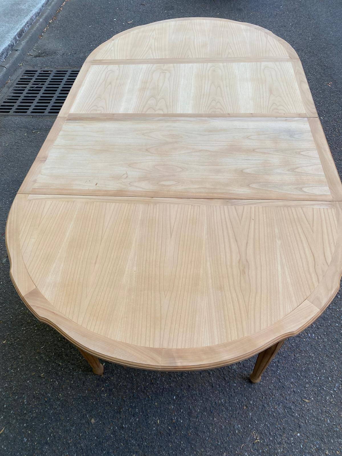 Extendable round table in renovated Louis XVI style, made of light wood, with 2 extensions.