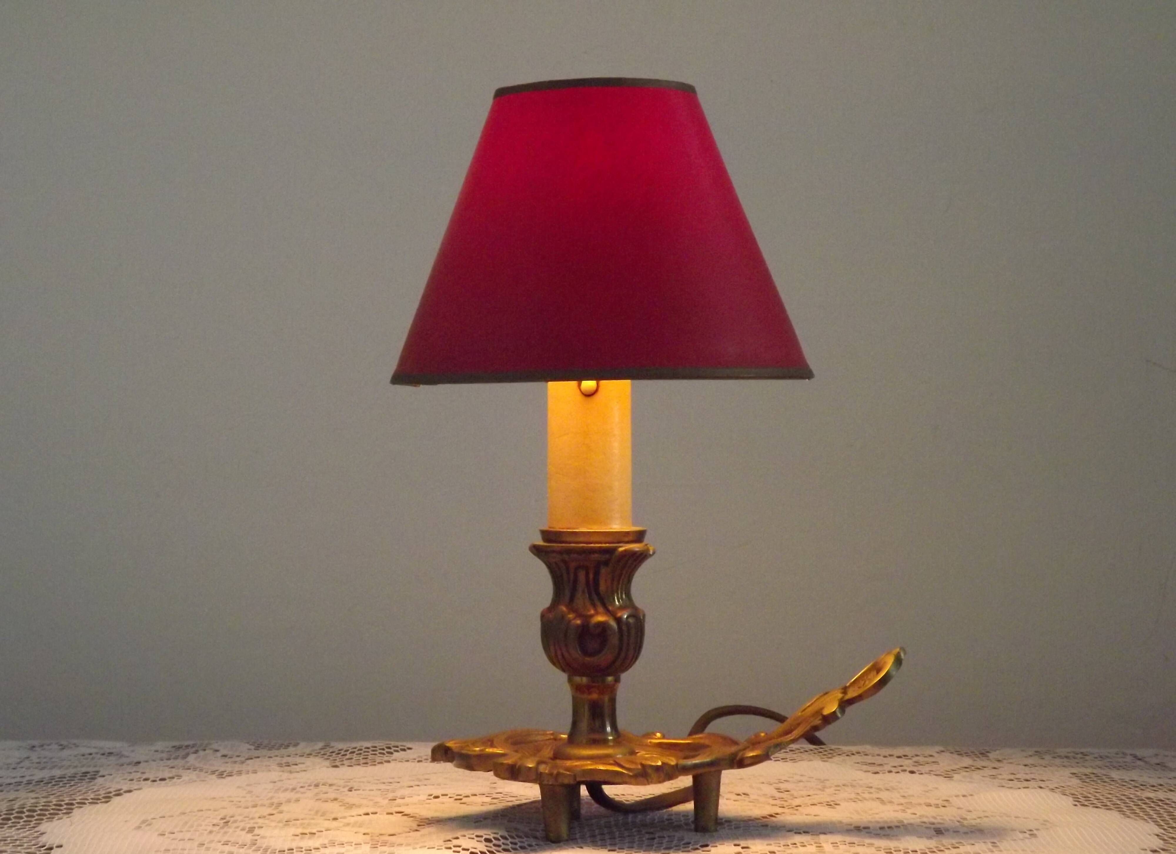 Vintage French bronze Wee Willie Winkie style lamp with red card shade.