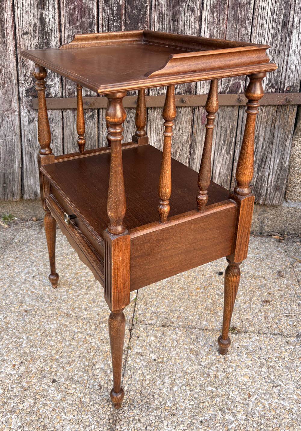 Solid wood bedside table with turned columns, early 20th century.