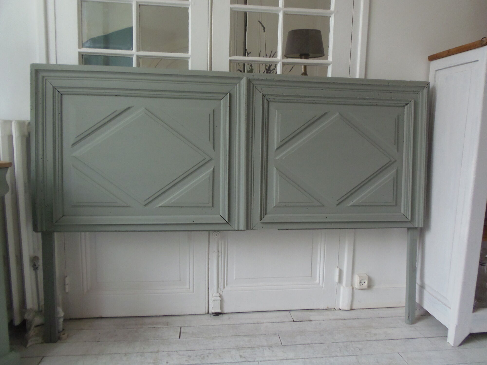 Headboard made with an old walnut door, re-enchanted in gray green waxed finish,
