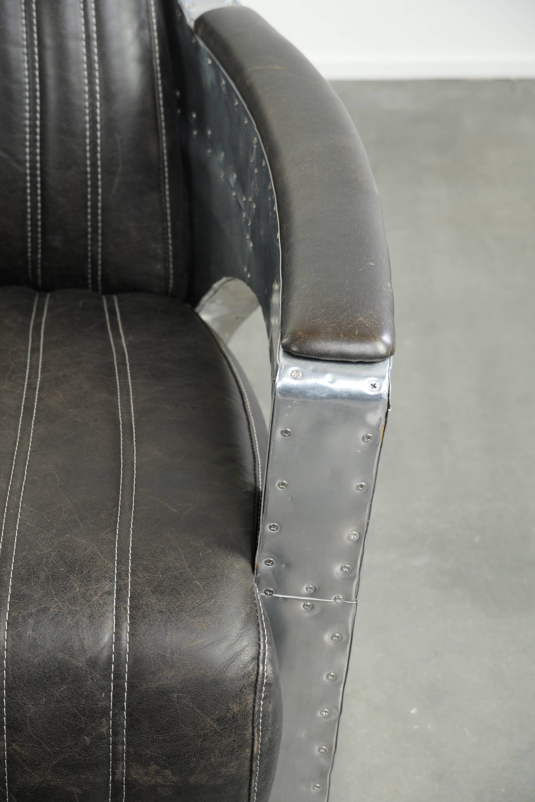 Cow leather aviator design armchair finished with aluminium and rivets
