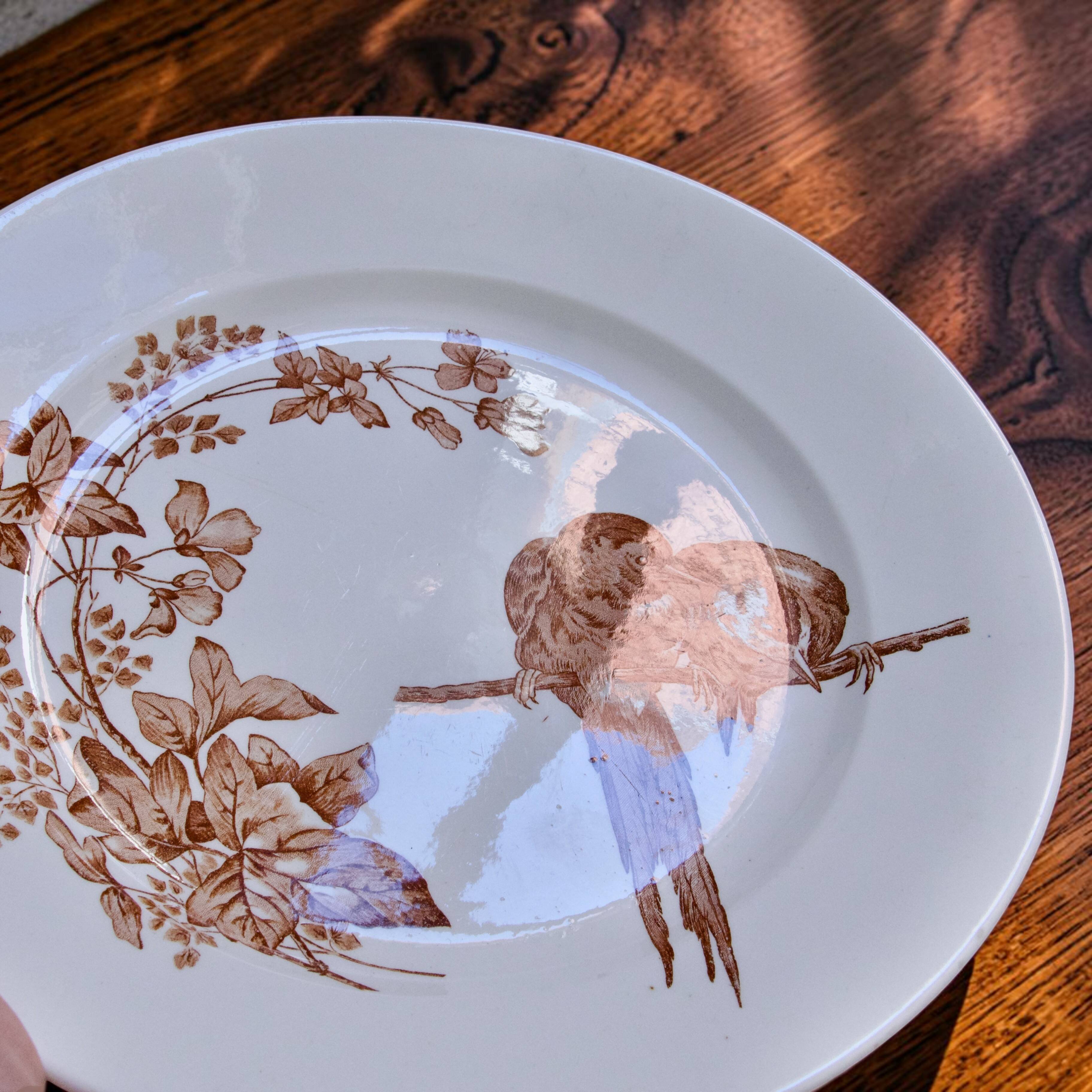 Large round dish from around 1870 signed Longwy with birds in sepia ironstone.