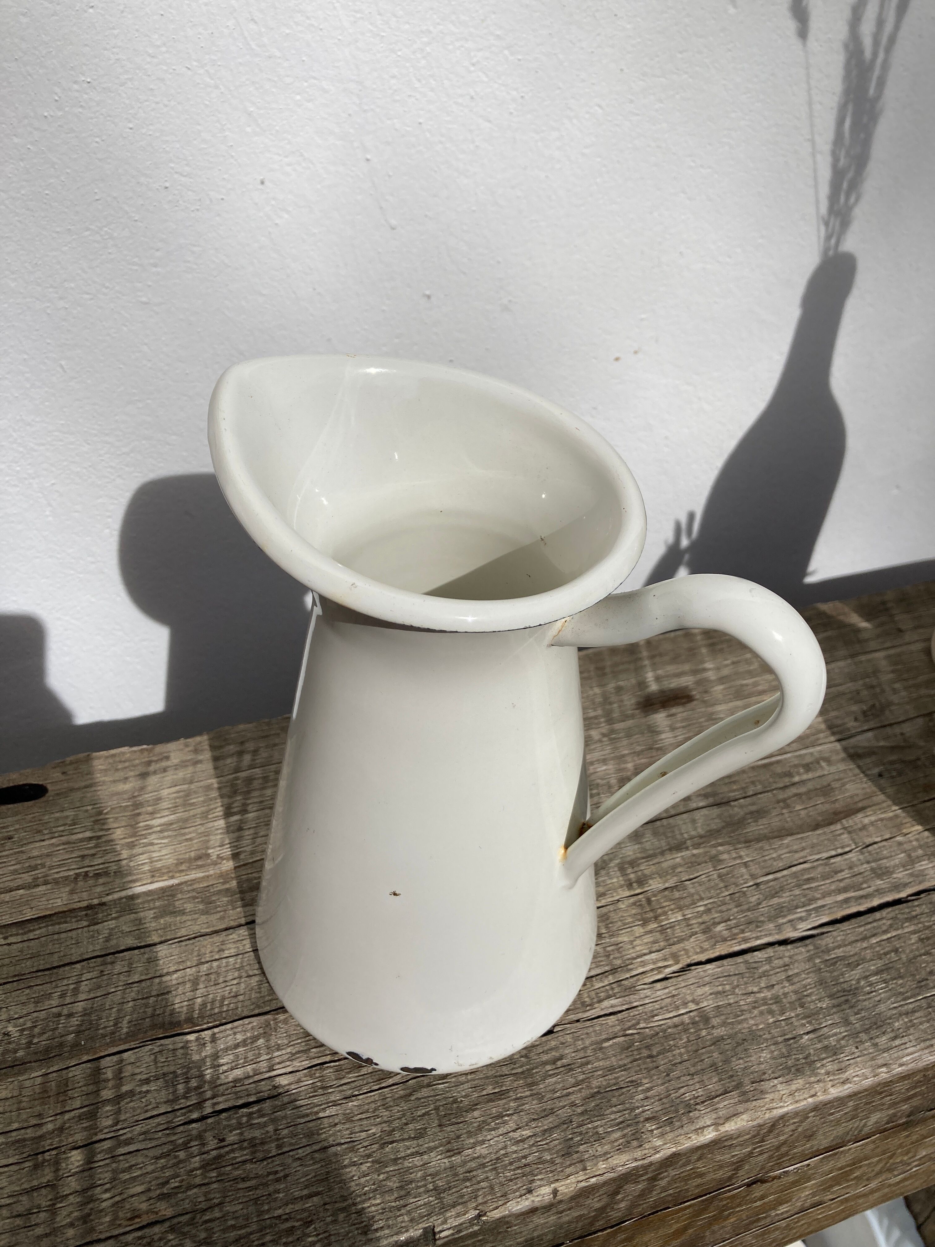 Old white enamelled metal pitcher
