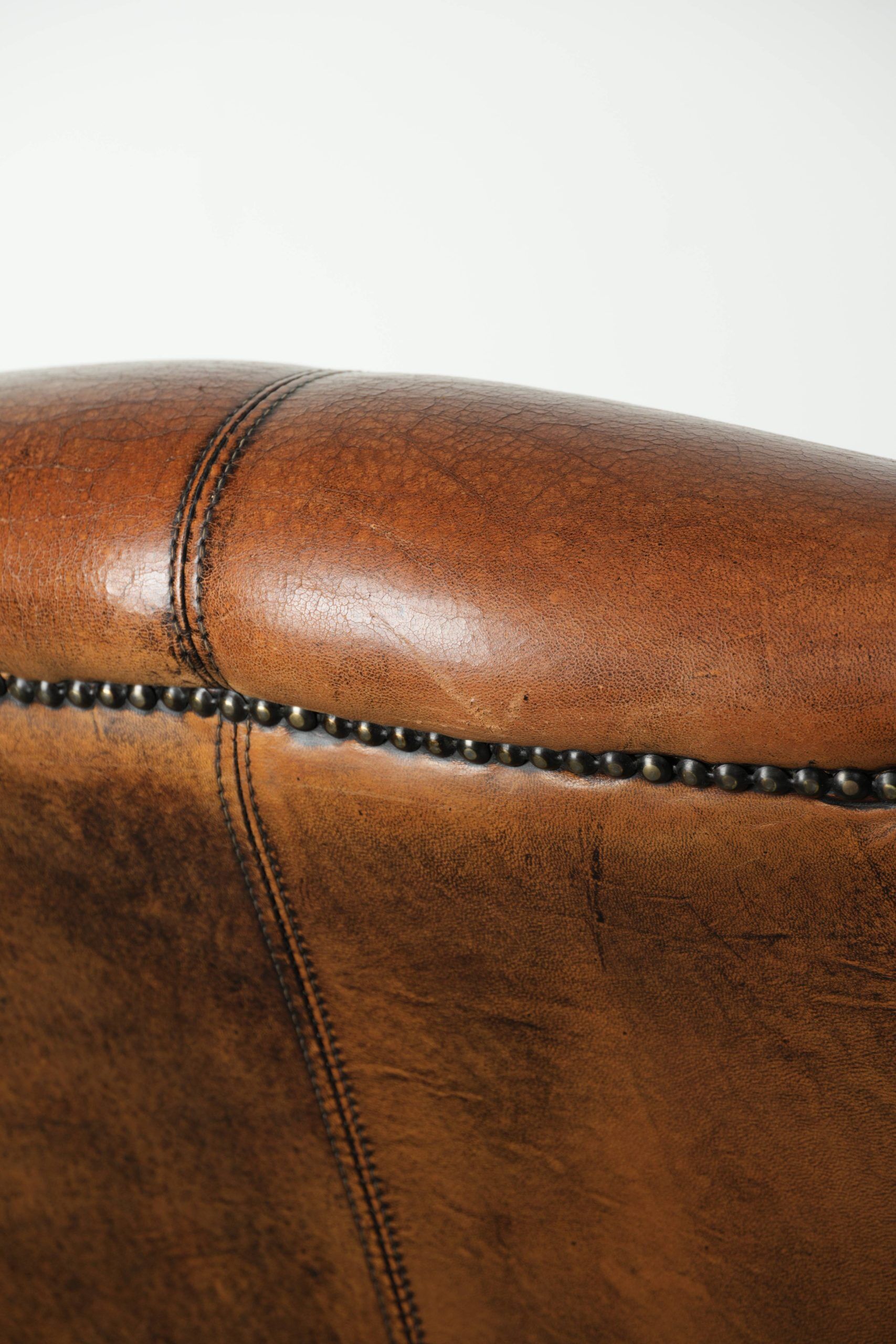 Wingback armchair made of sheepskin leather finished with decorative nails
