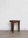 Antique stool made of raw wood carved from a single trunk