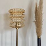 Table lamp with a golden striated globe and a golden base