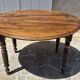 Round dining table with a drop-leaf top in solid walnut, late 19th century.