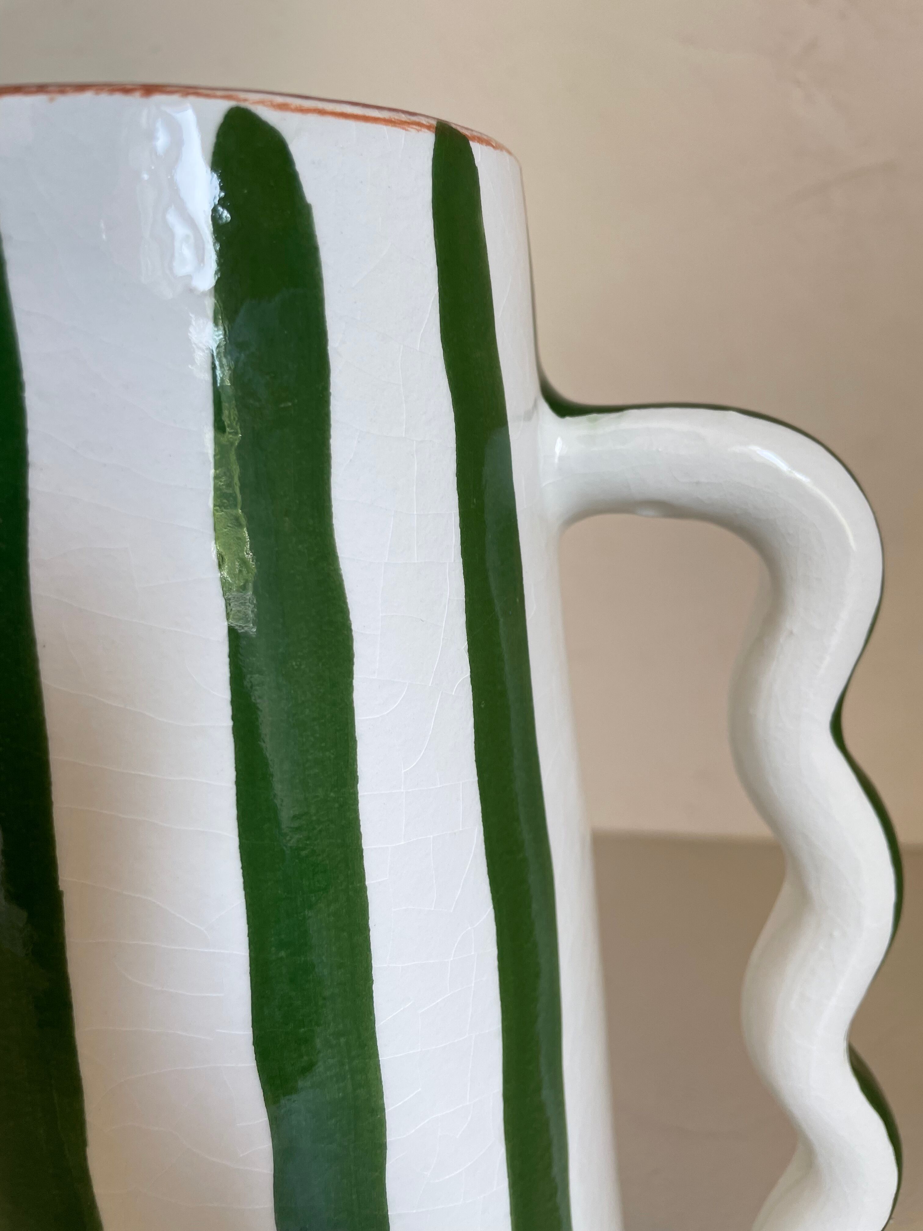 Green and white striped ceramic vase with abstract handmade corrugated handheld
