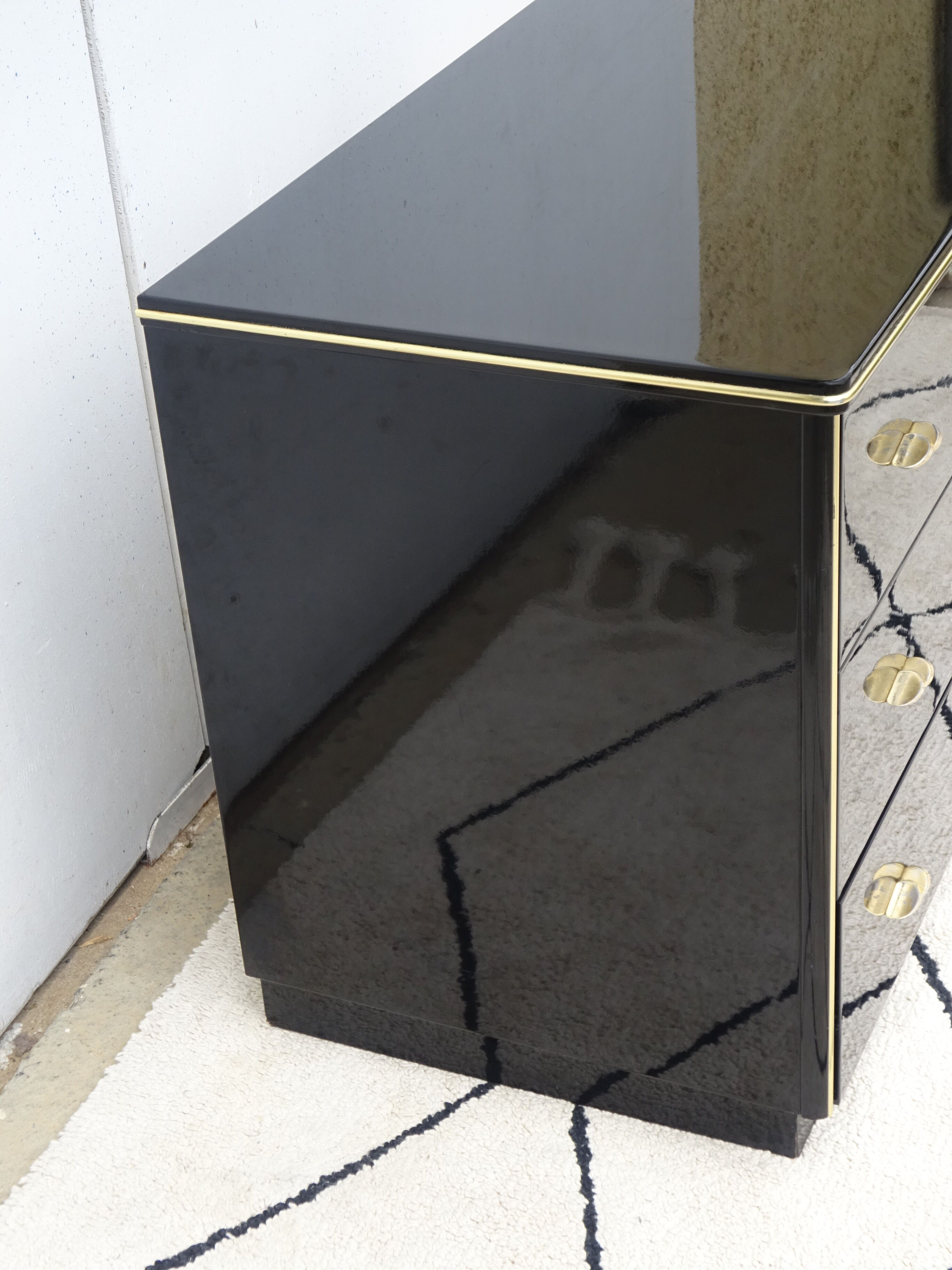 Lacquered black chest of drawers, golden brass