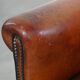 Sheepskin leather armchair in a cognac color with black piping