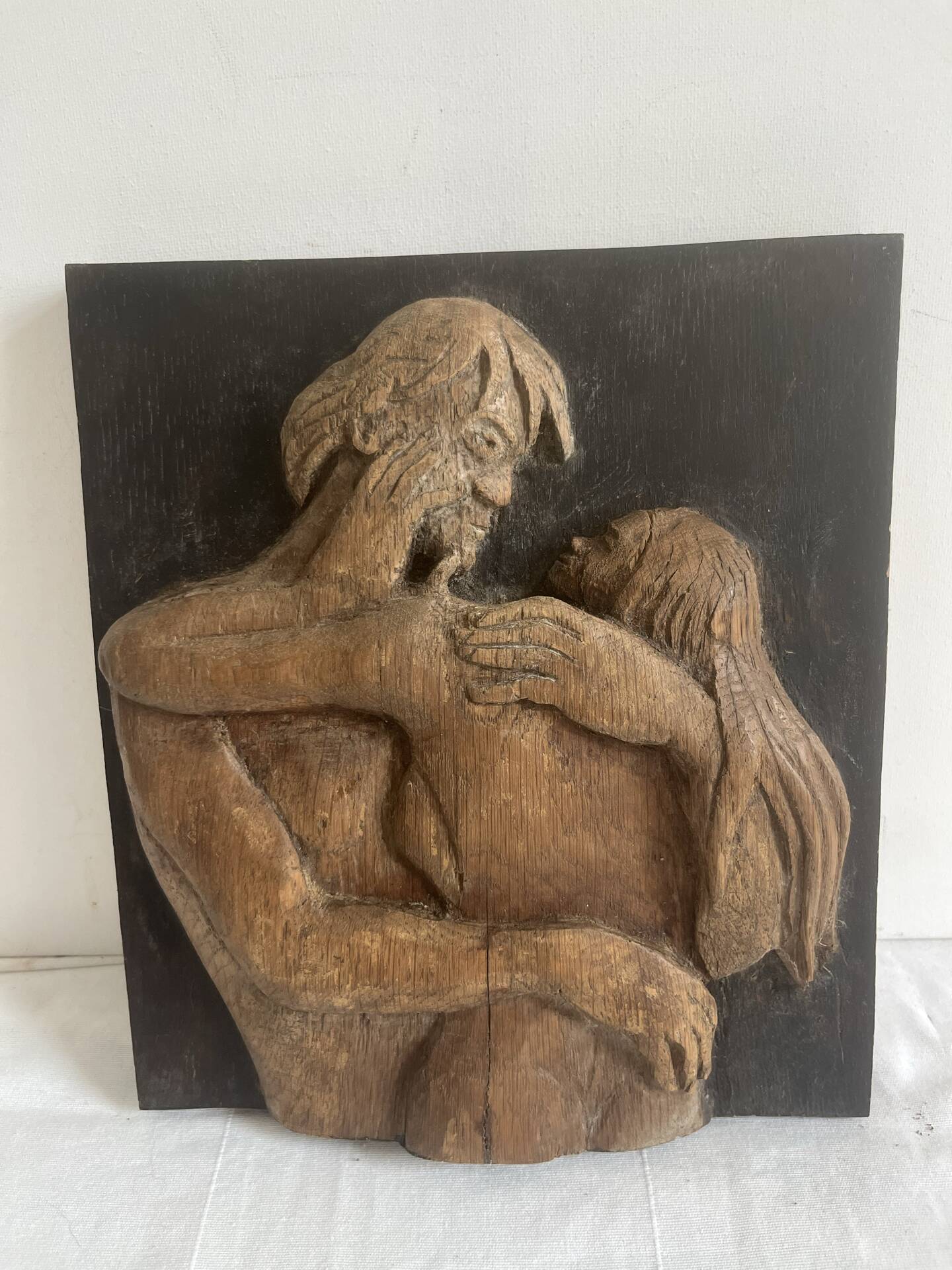 Wood sculpture bas-relief of man, woman, and child, signed.