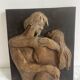 Wood sculpture bas-relief of man, woman, and child, signed.