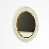 Mid Century Modern round wall mirror with a white expanded metal frame
