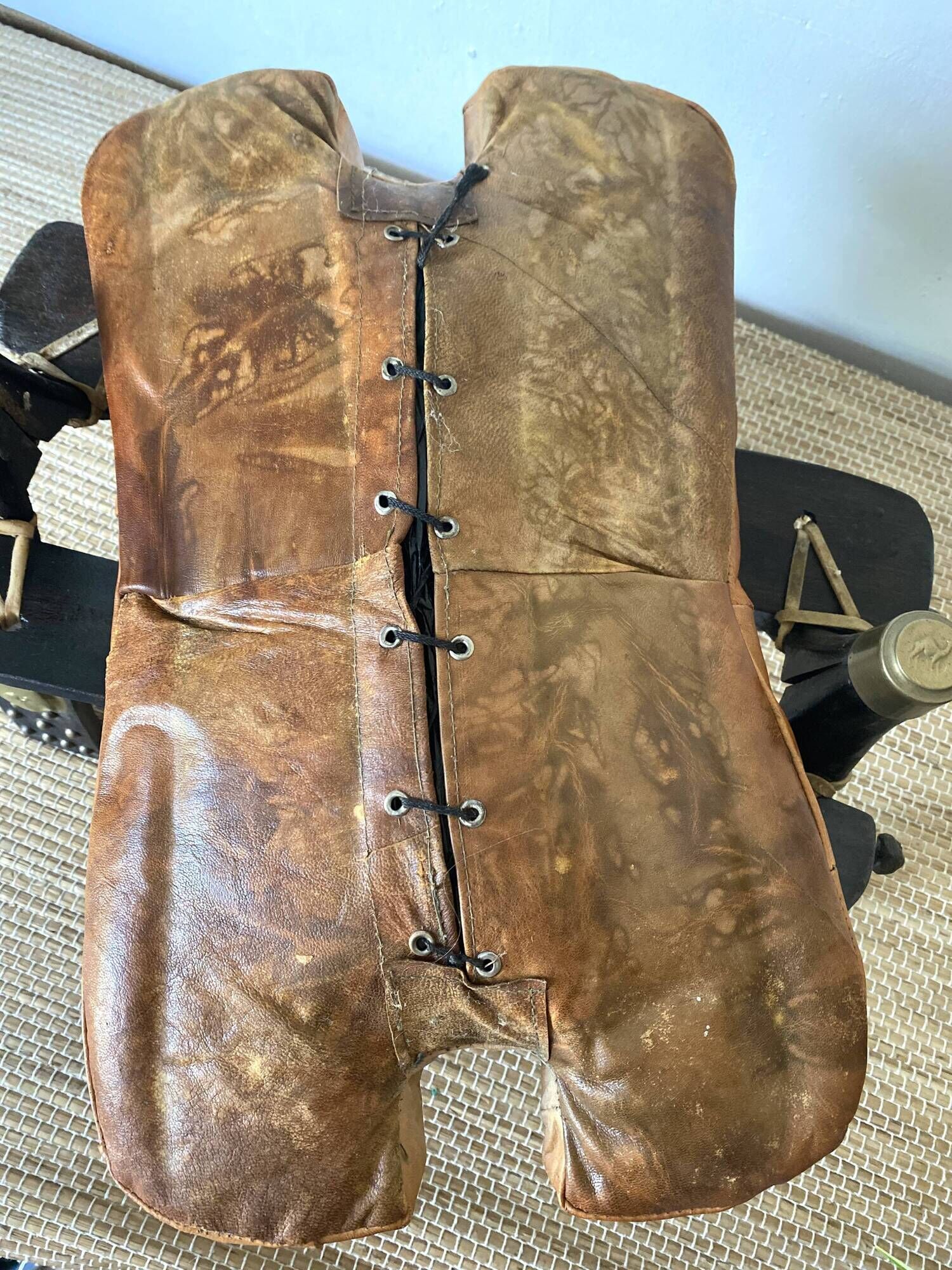 Pair of low Egyptian stools, camel saddles in wood, leather and brass