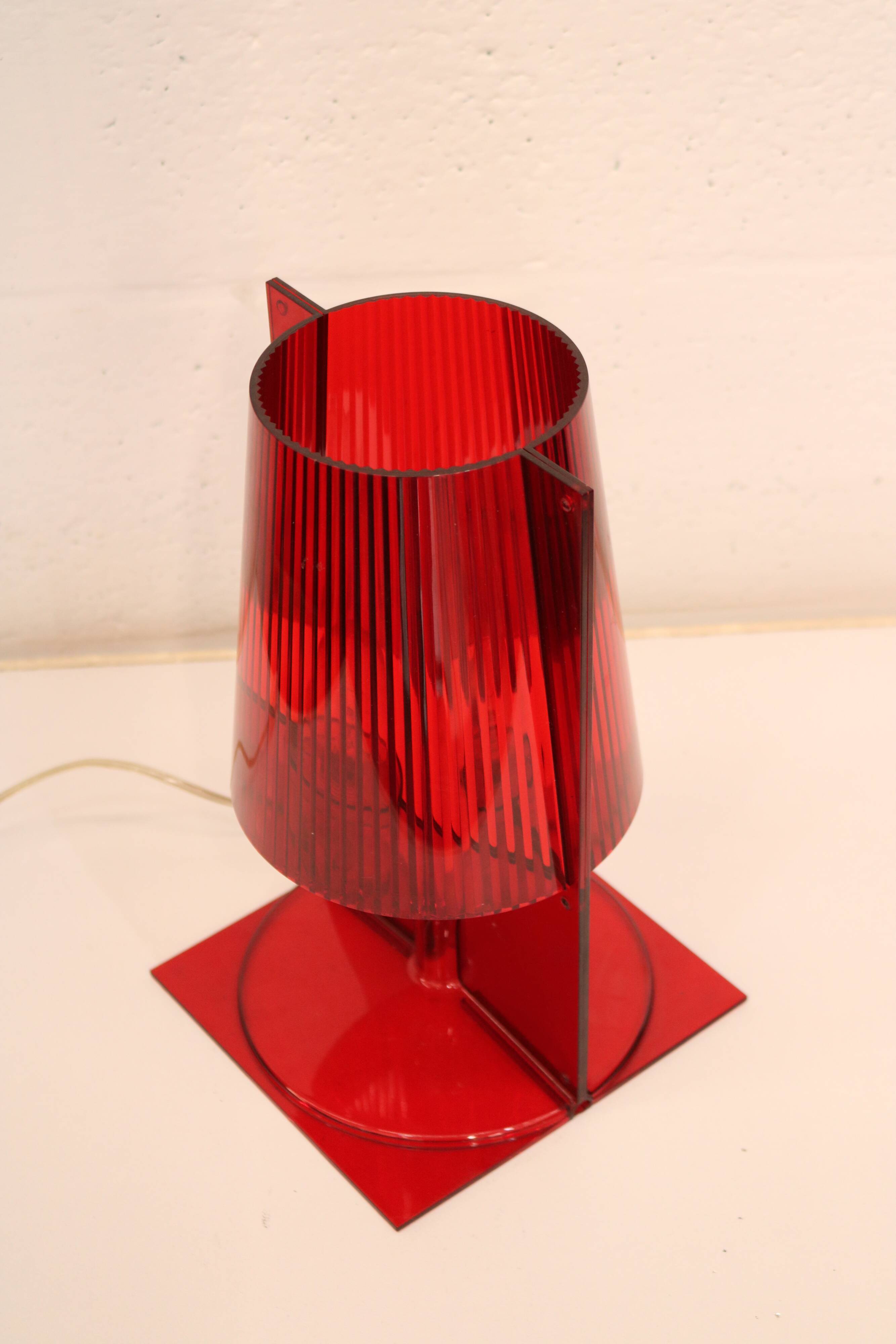 Red plastic Kartell table lamp - model Take - design by Ferruccio Laviani