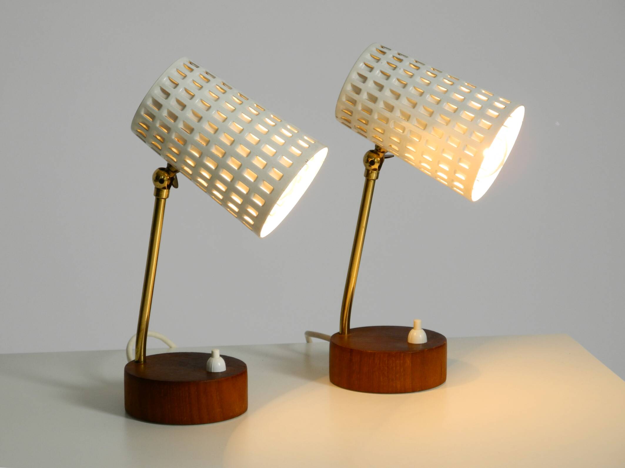 A pair of mid-century modern bedside lamps with perforated metal shades