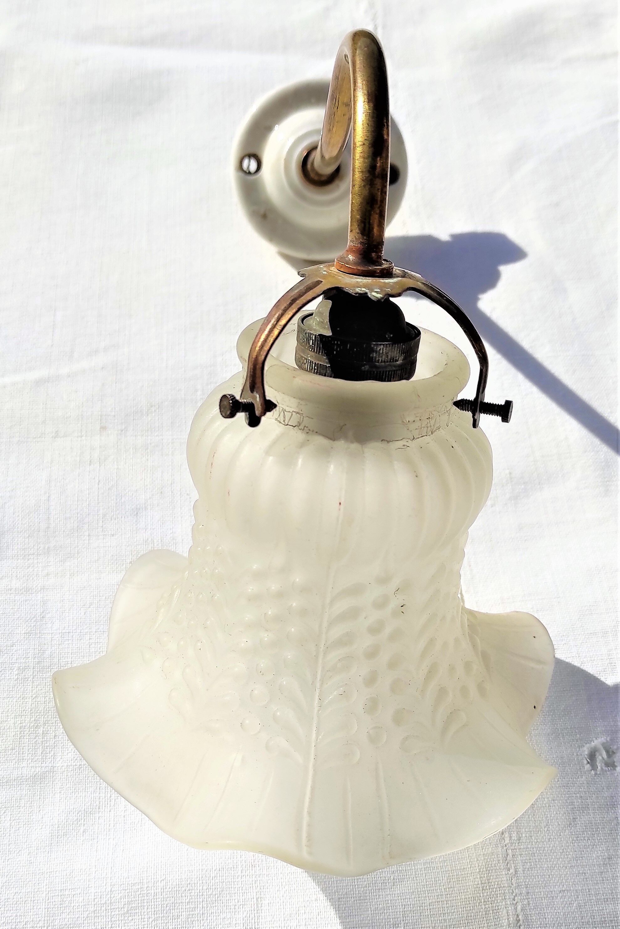 Brass gooseneck wall lamp, with brass socket and porcelain base.