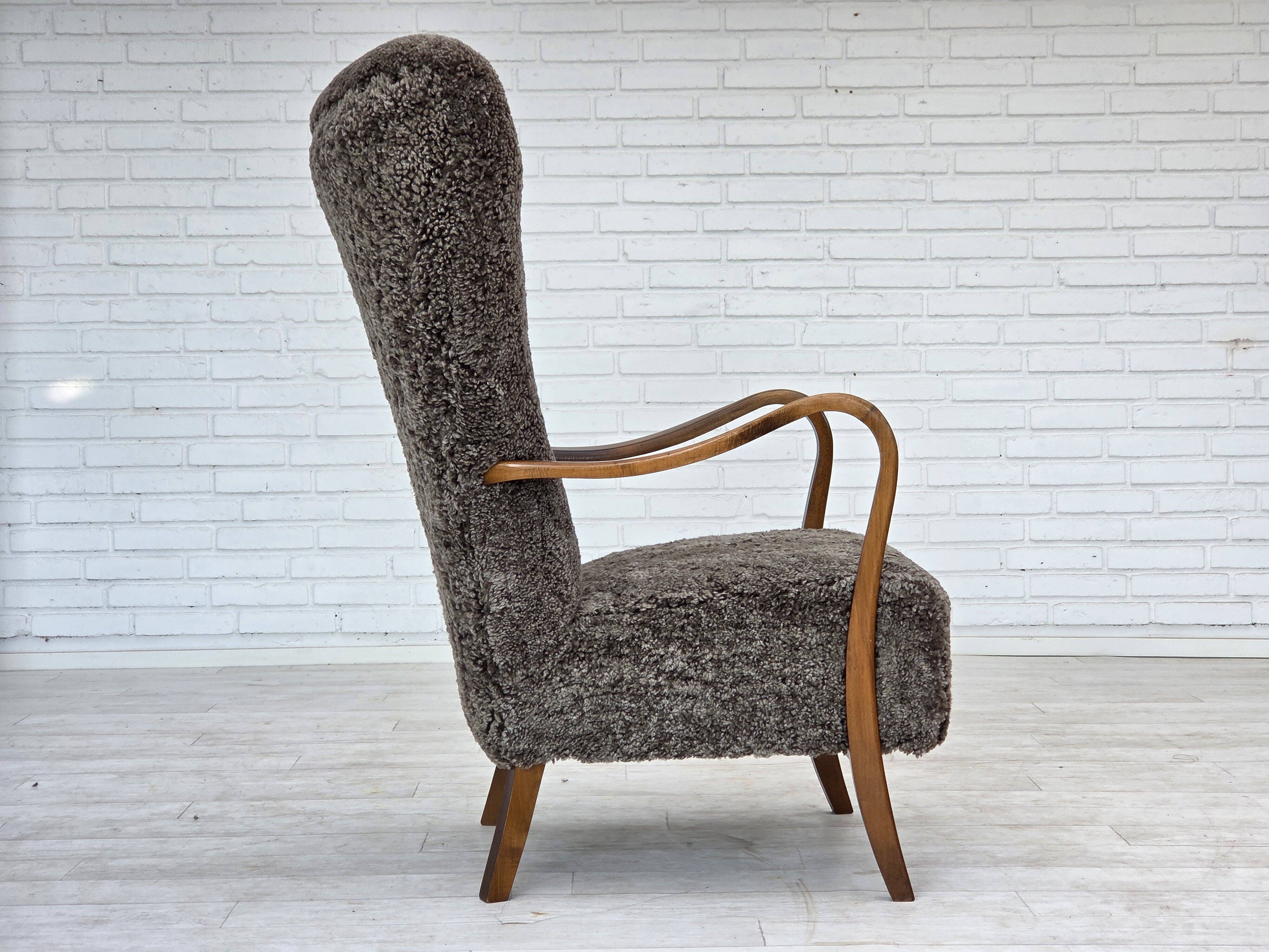 1960s, reupholstered Danish armchair, with stool, genuine sheepskin.