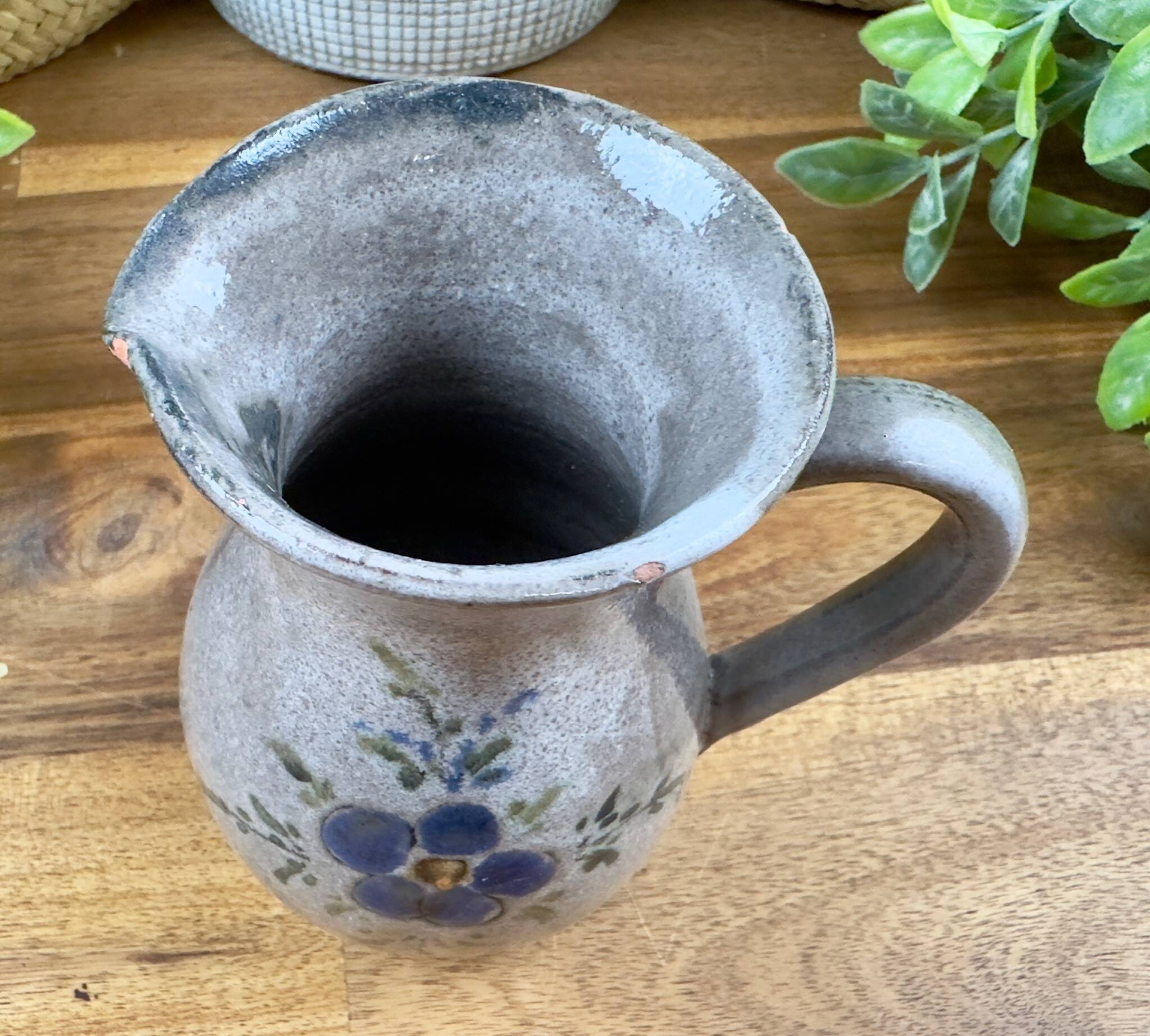 Vintage grey ceramic pitcher with hand-painted blue flower decoration.