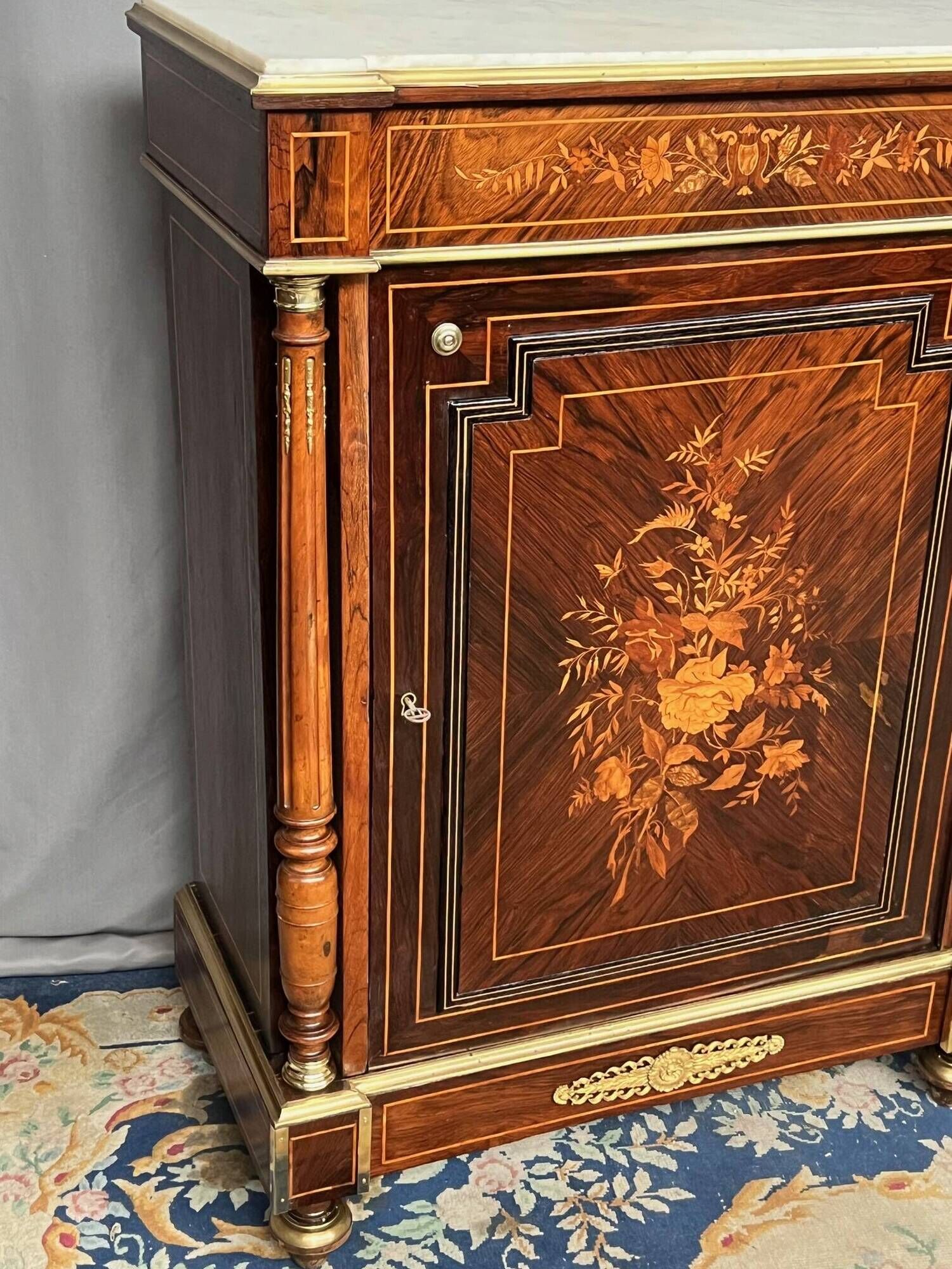 Elegant Napoleon III style commode with fine marquetry, gilded bronze mounts, and a marble top.