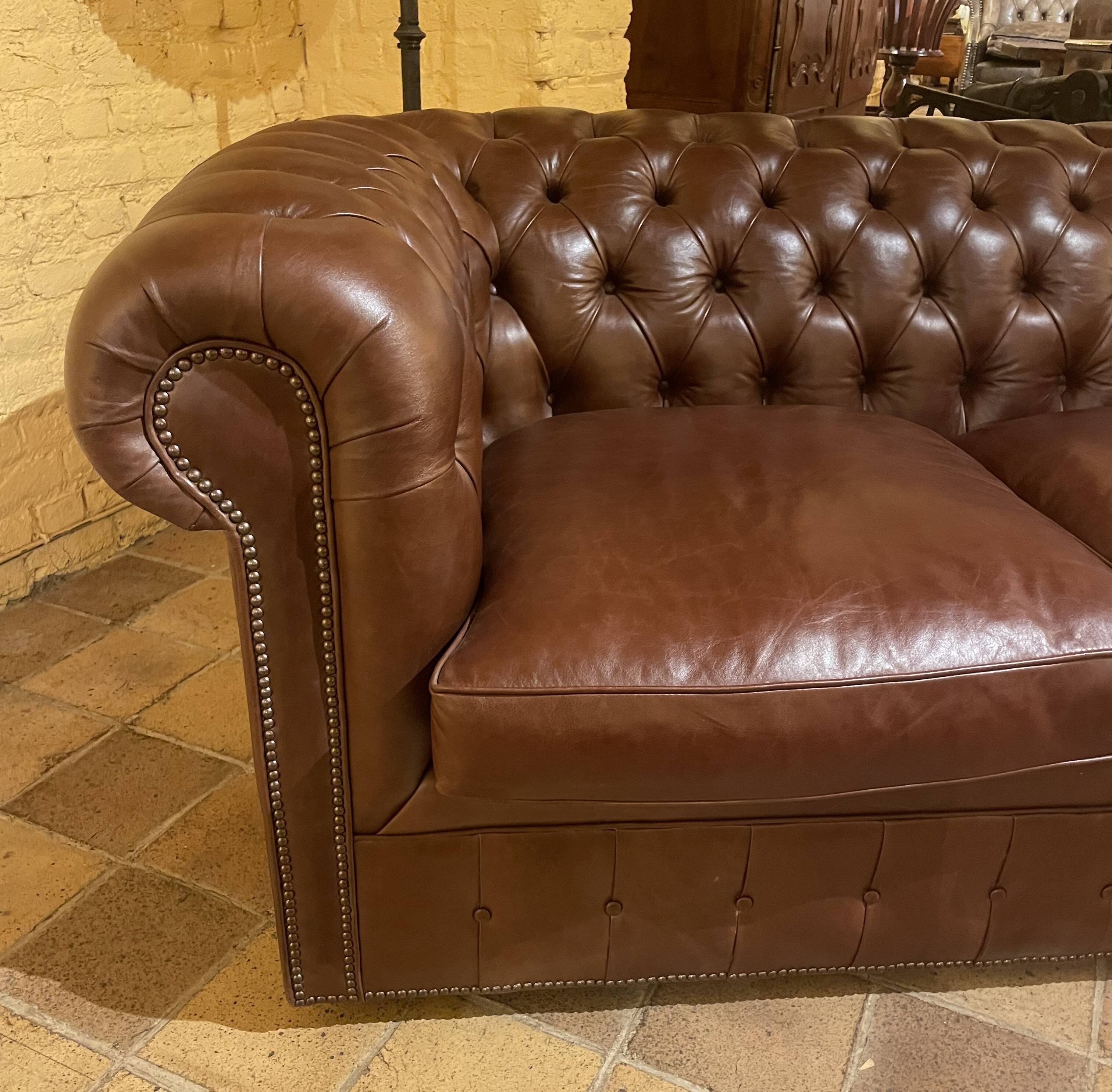 brown leather 2-seater Chesterfield sofa