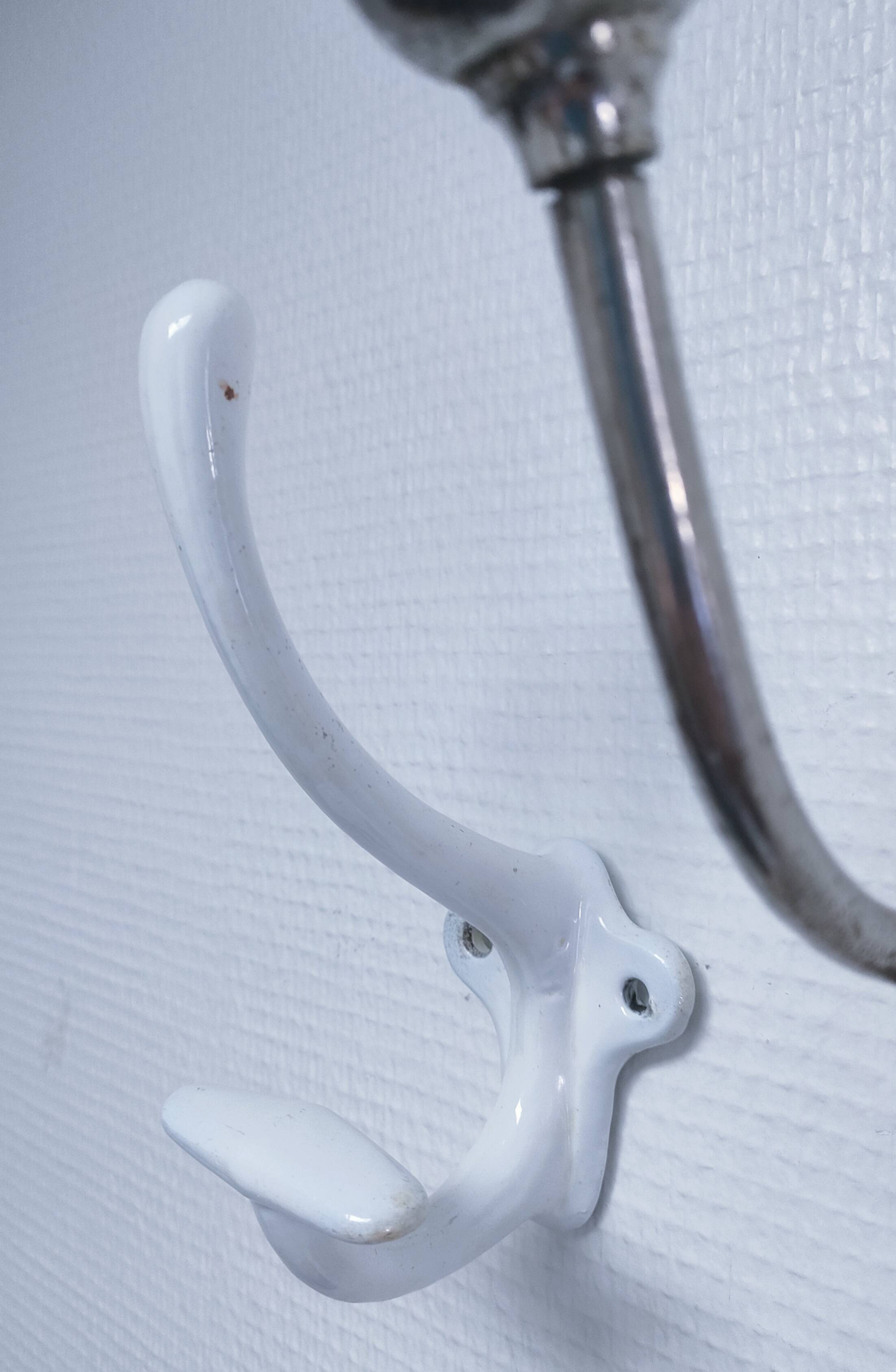 Three enameled cast iron coat hooks and vintage patina metal