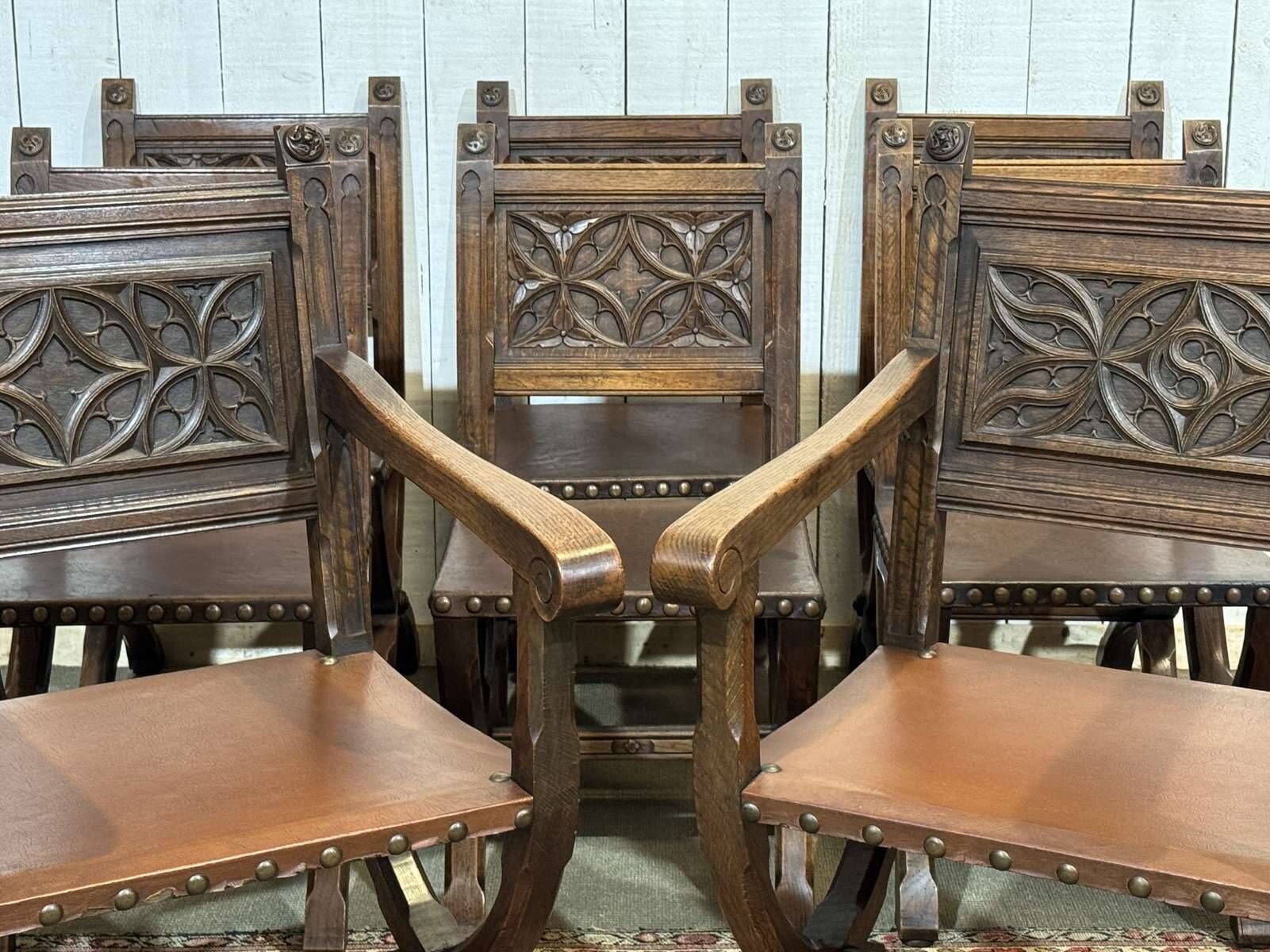 Suite de 6 chaises et 2 fauteuils en chêne et cuir à décor gothique