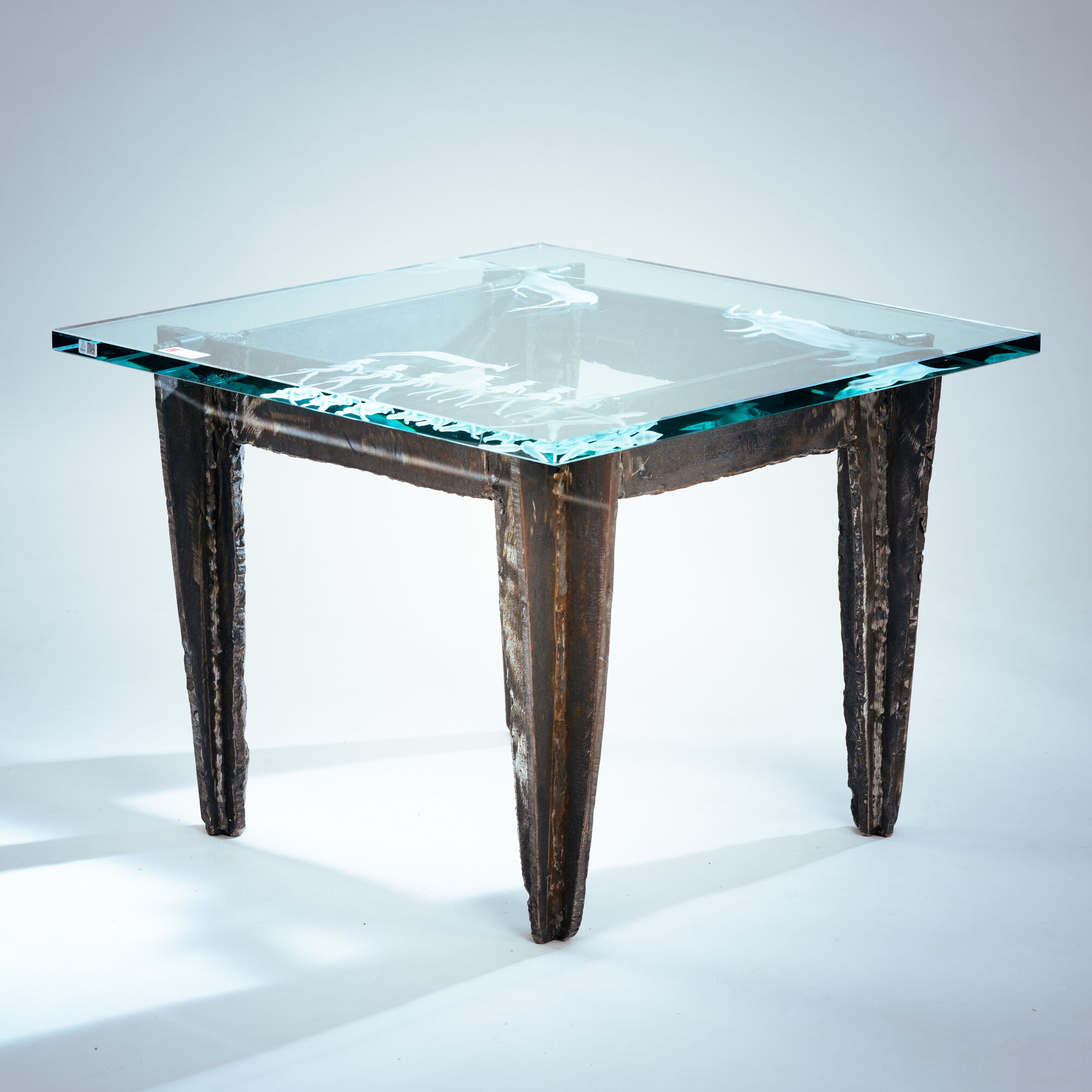 2 brutalist steel side tables with primitive  scene motifs etched glass