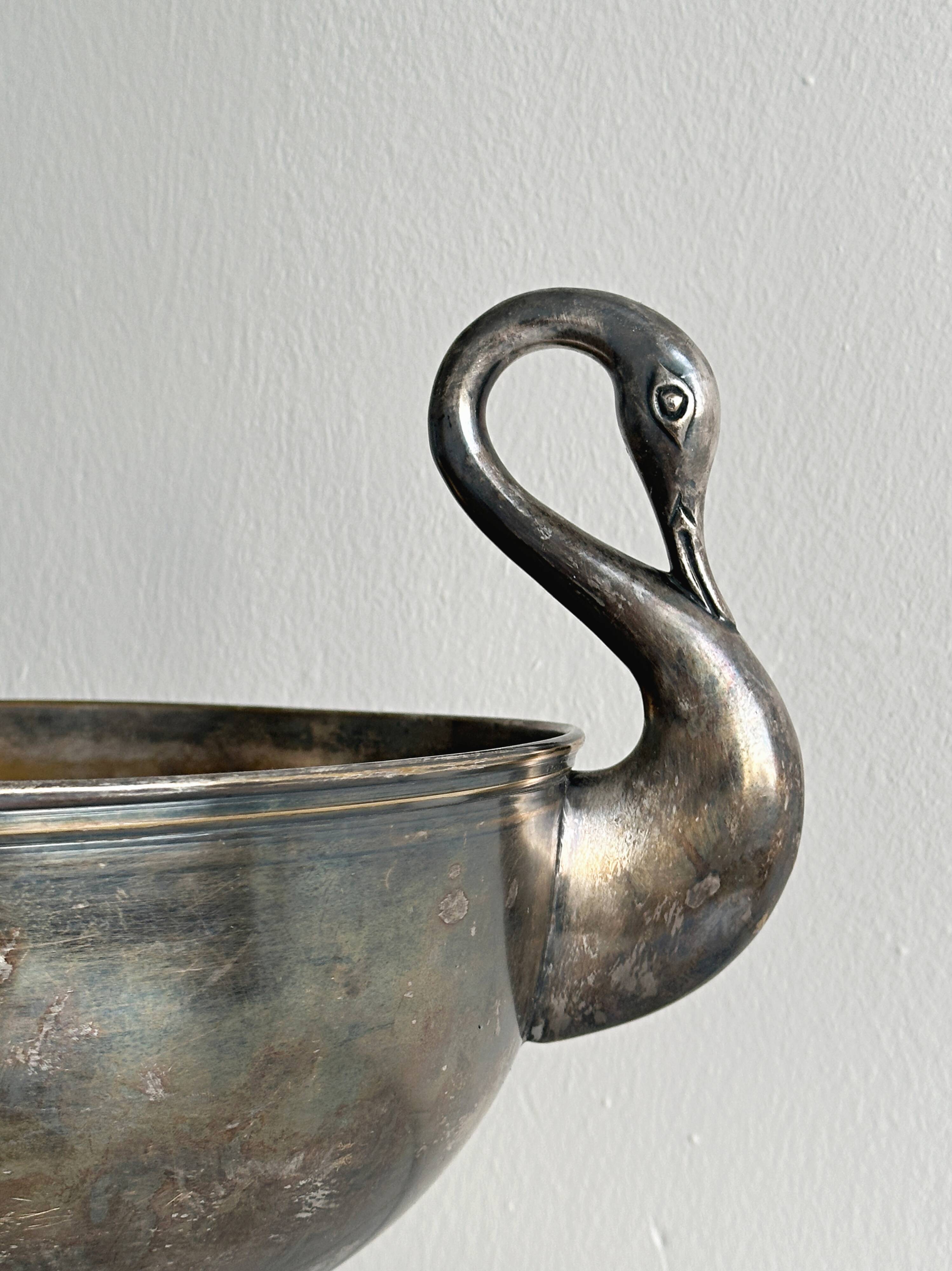 Large champagne bucket with patinated metal swan handles.