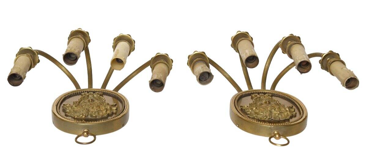 Pair of wall sconces with a relief decoration of a Bacchus mask.