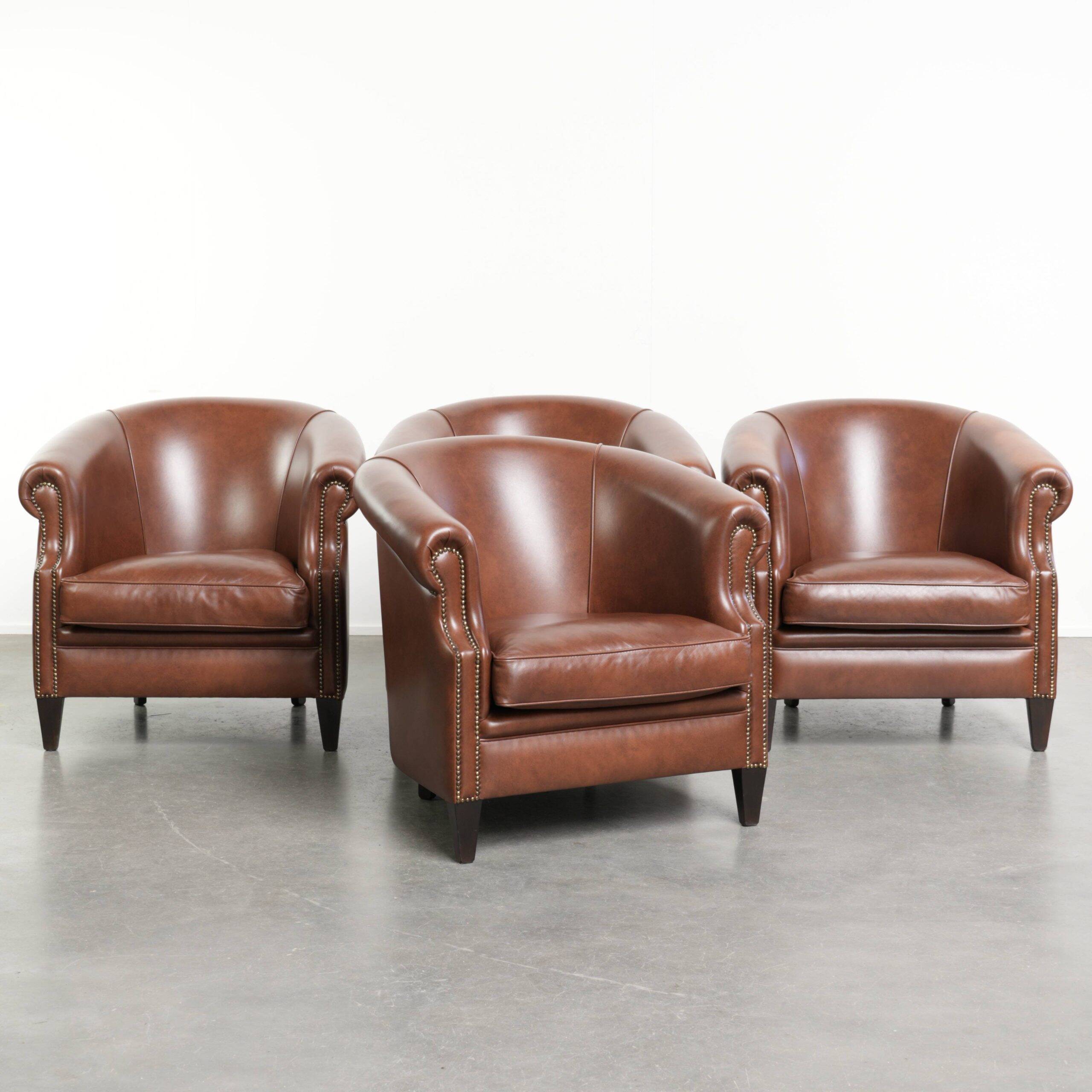 Ensemble de 4 fauteuils club en cuir de vache couleur cognac foncé de style anglais.