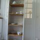 Shallow depth bookcase re-enchanted in pearl gray, wooden shelves.