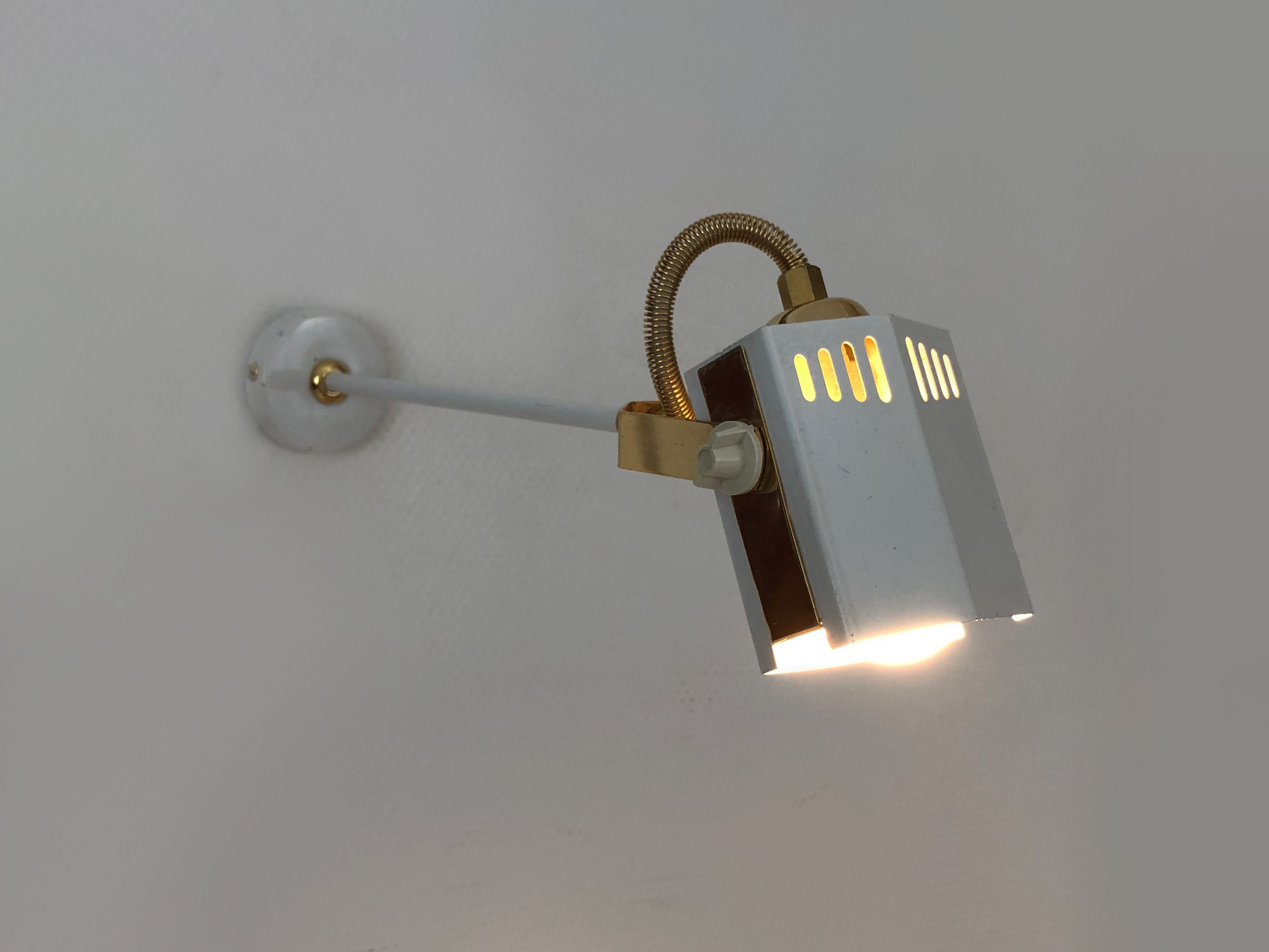 Pair of spot wall lamps adjustable design in white metal and brass. Year 80
