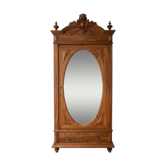 Antique solid wood wardrobe with an oval mirror.
