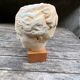 Plaster head of an ancient goddess on its wooden base