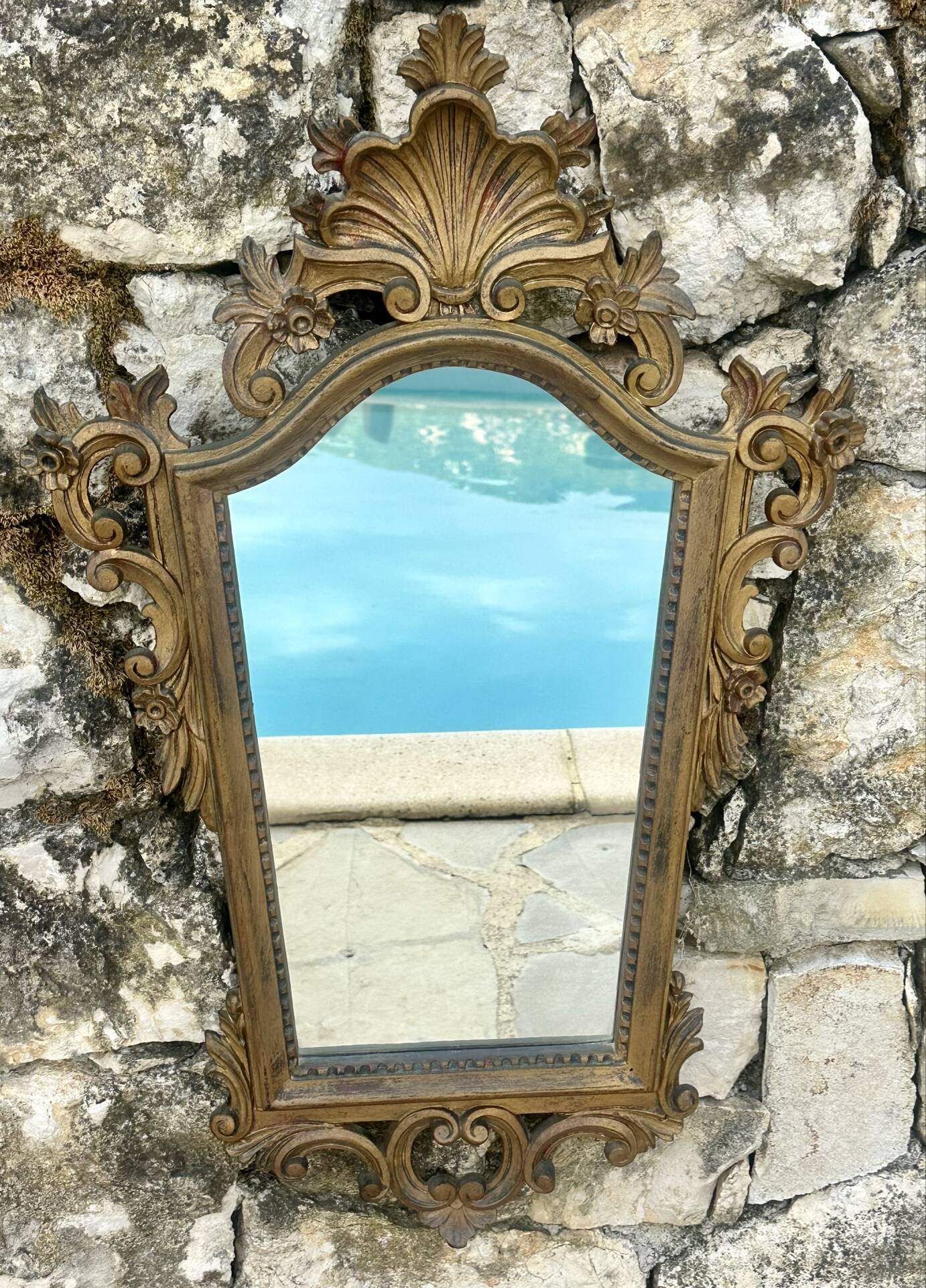 Carved and gilded wooden wall mirror.