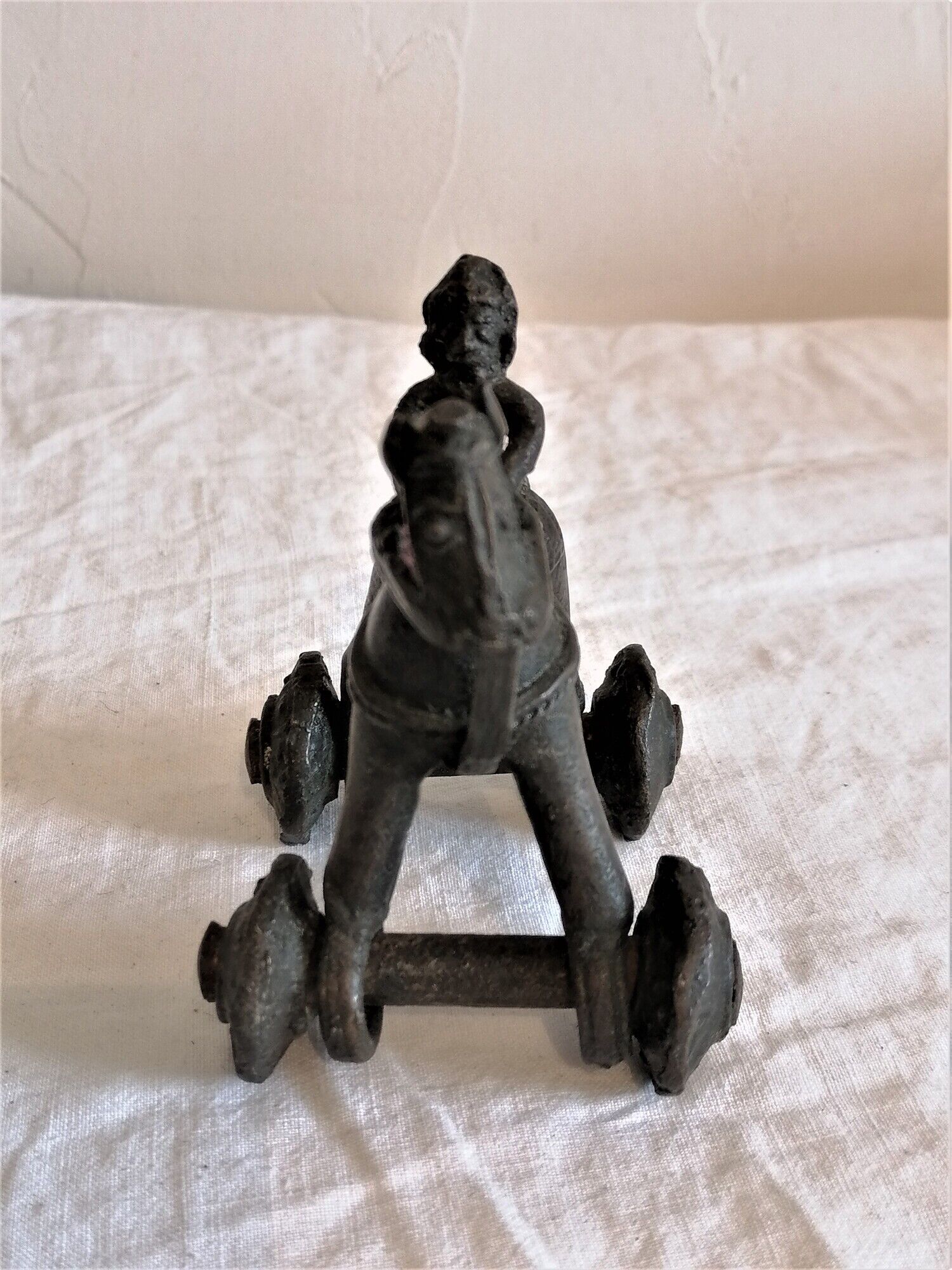Old child's toy. Horse with bronze wheels. Ethnic object.