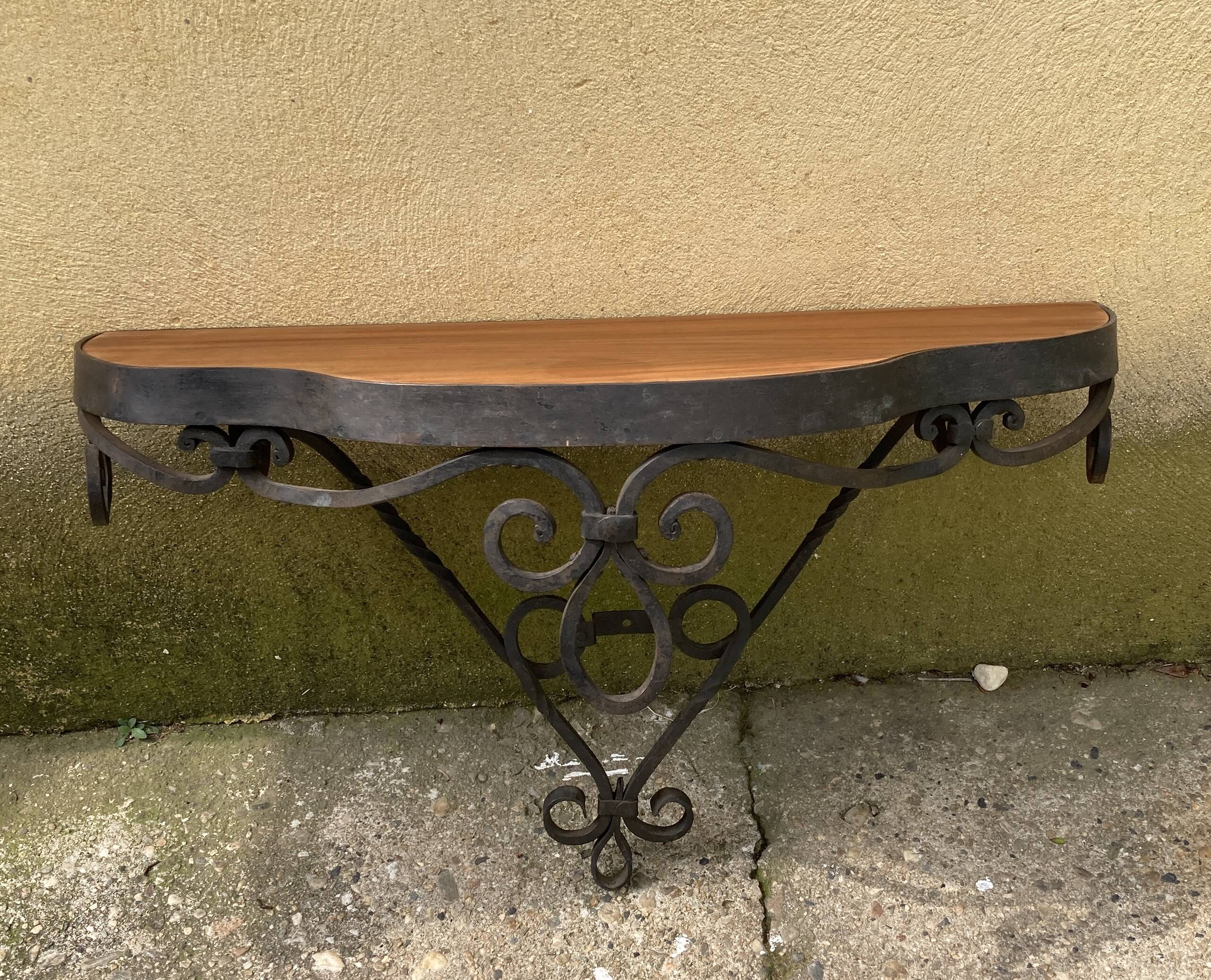Old wrought iron console with a fleur-de-lis design.