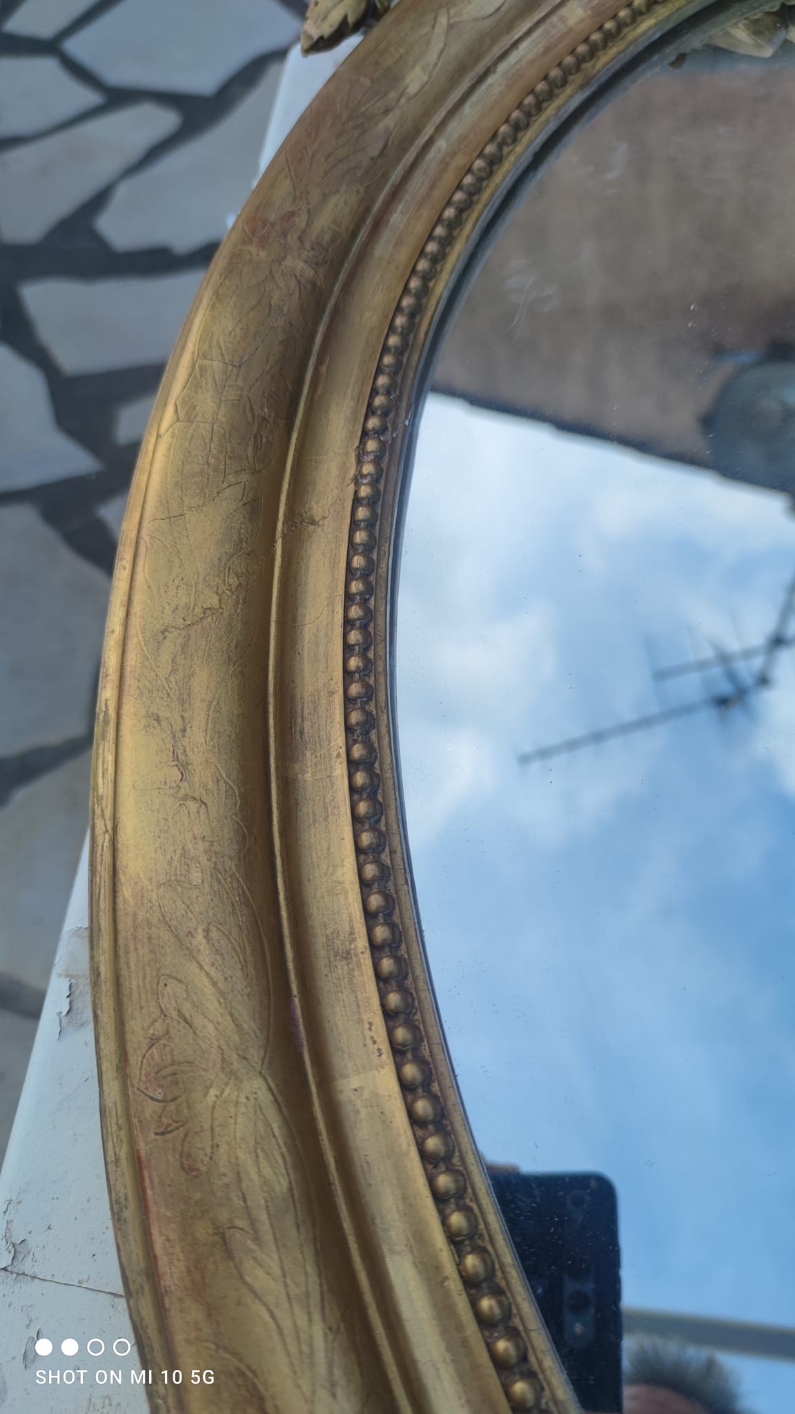 Ovoid mirror with double gilt pediments, circa 1830, 105x66 cm