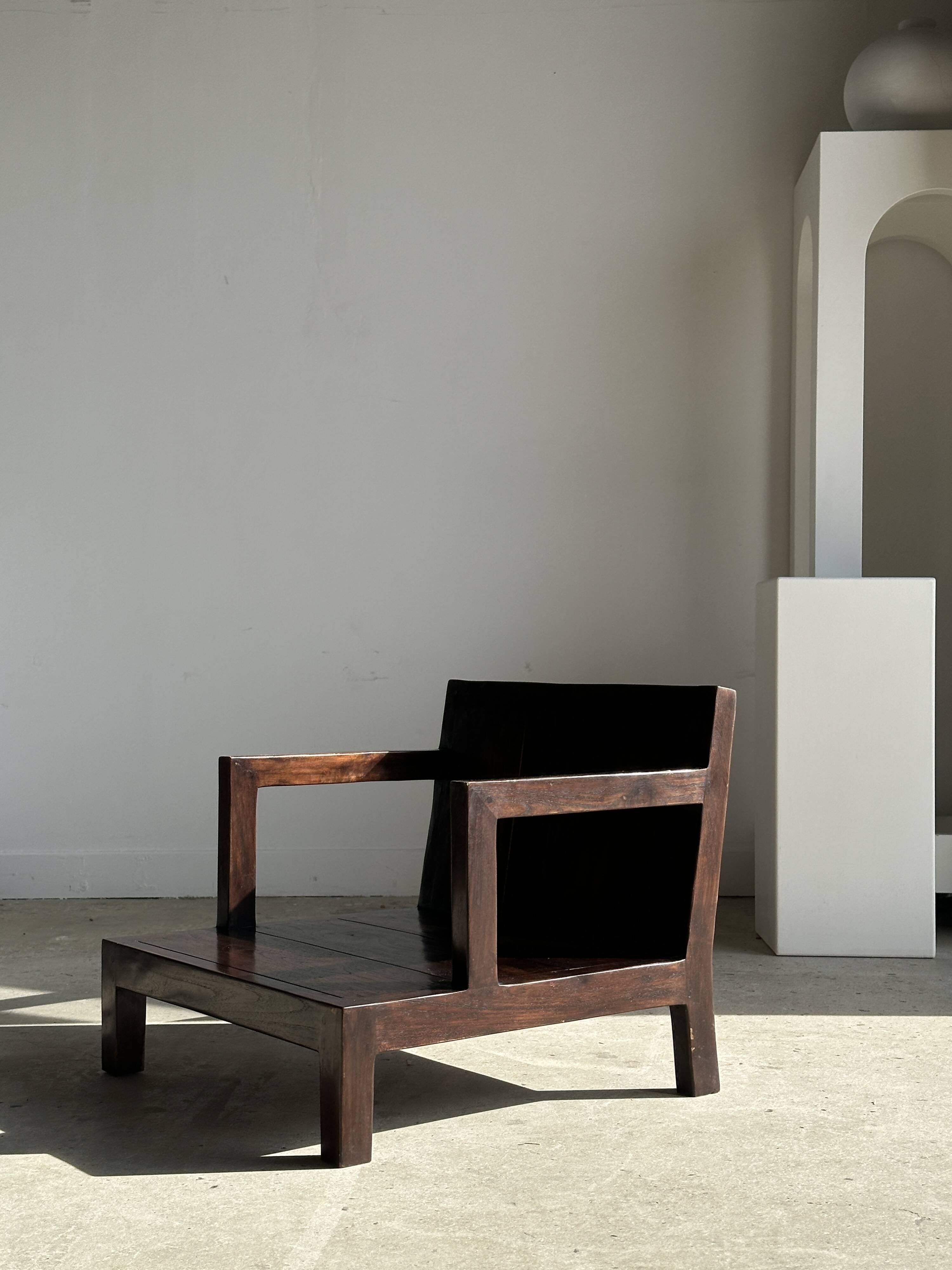 Small low armchair in varnished brown wood