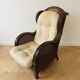 Vintage armchair in rattan and wicker with beige cushion.