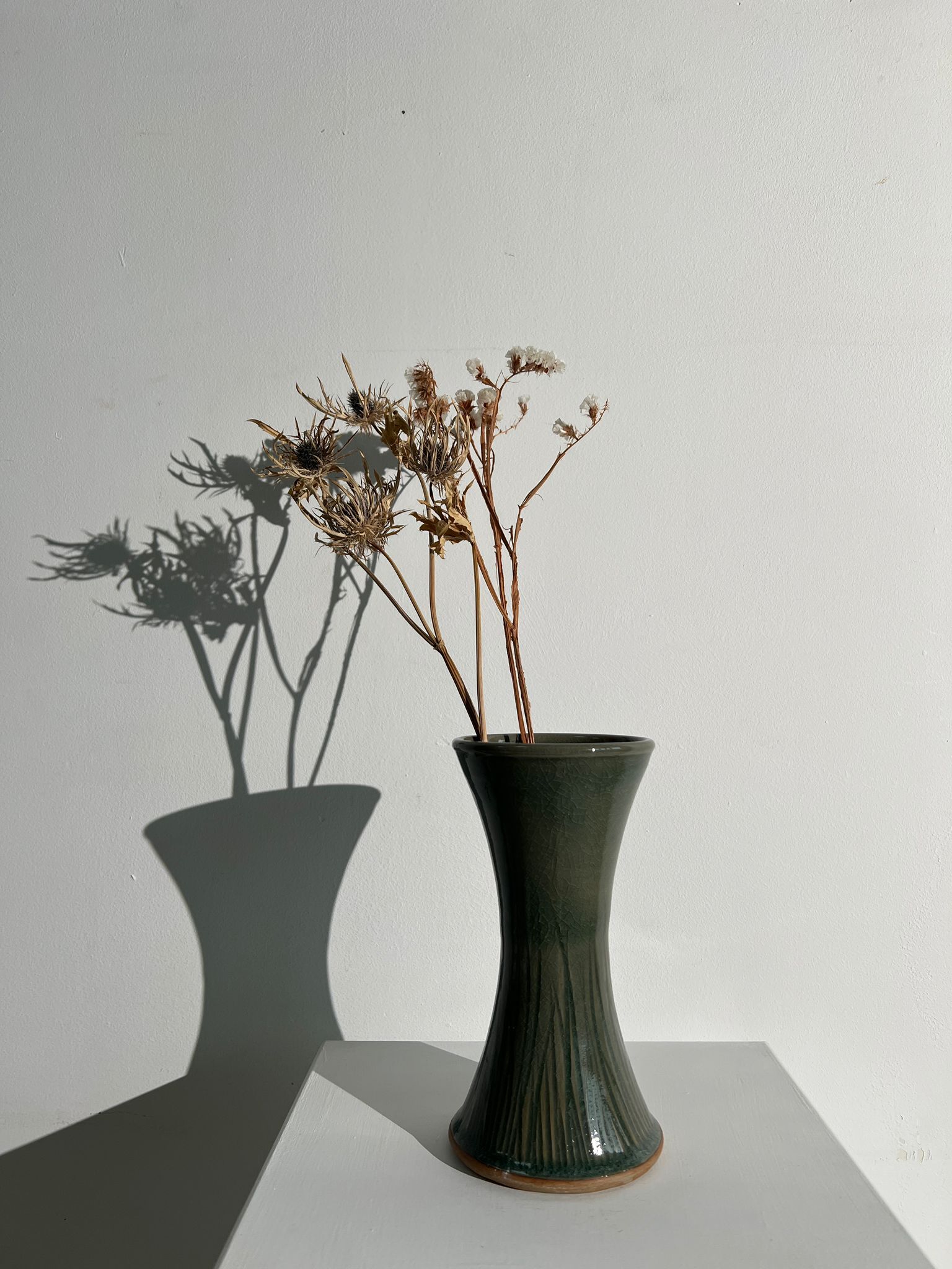 Dark green handcrafted vase with glazed ceramic grass blades